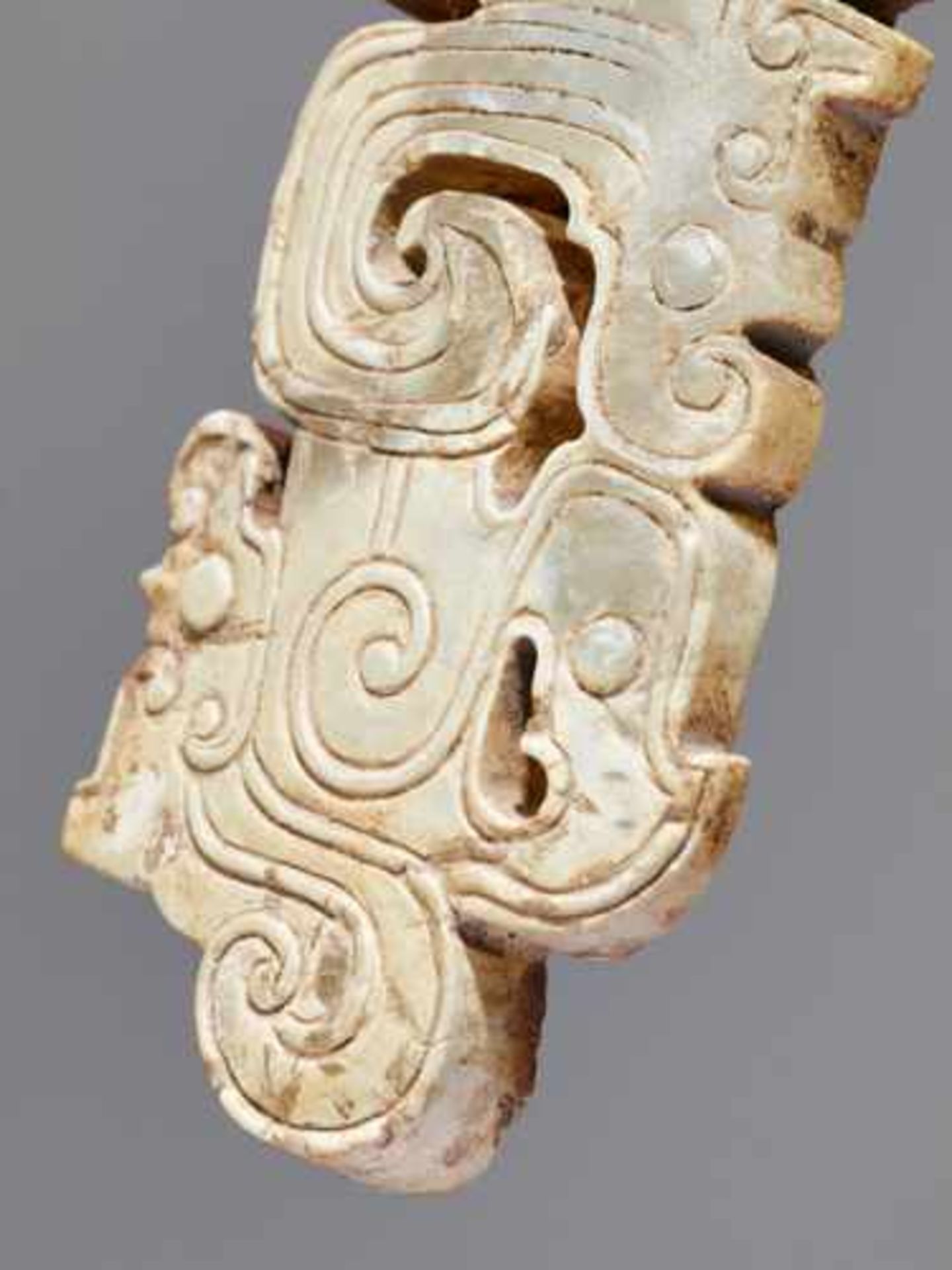 A SCULPTURAL ORNAMENT WITH A COMPOSITE MOTIF OF HUMAN HEADS AND DRAGONS Jade, China. Western Zhou, - Image 5 of 10