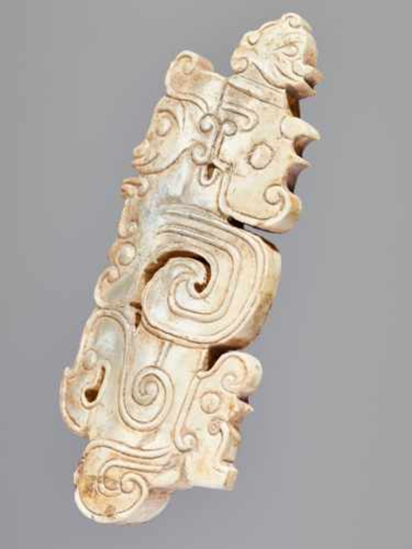 A SCULPTURAL ORNAMENT WITH A COMPOSITE MOTIF OF HUMAN HEADS AND DRAGONS Jade, China. Western Zhou, - Image 9 of 10