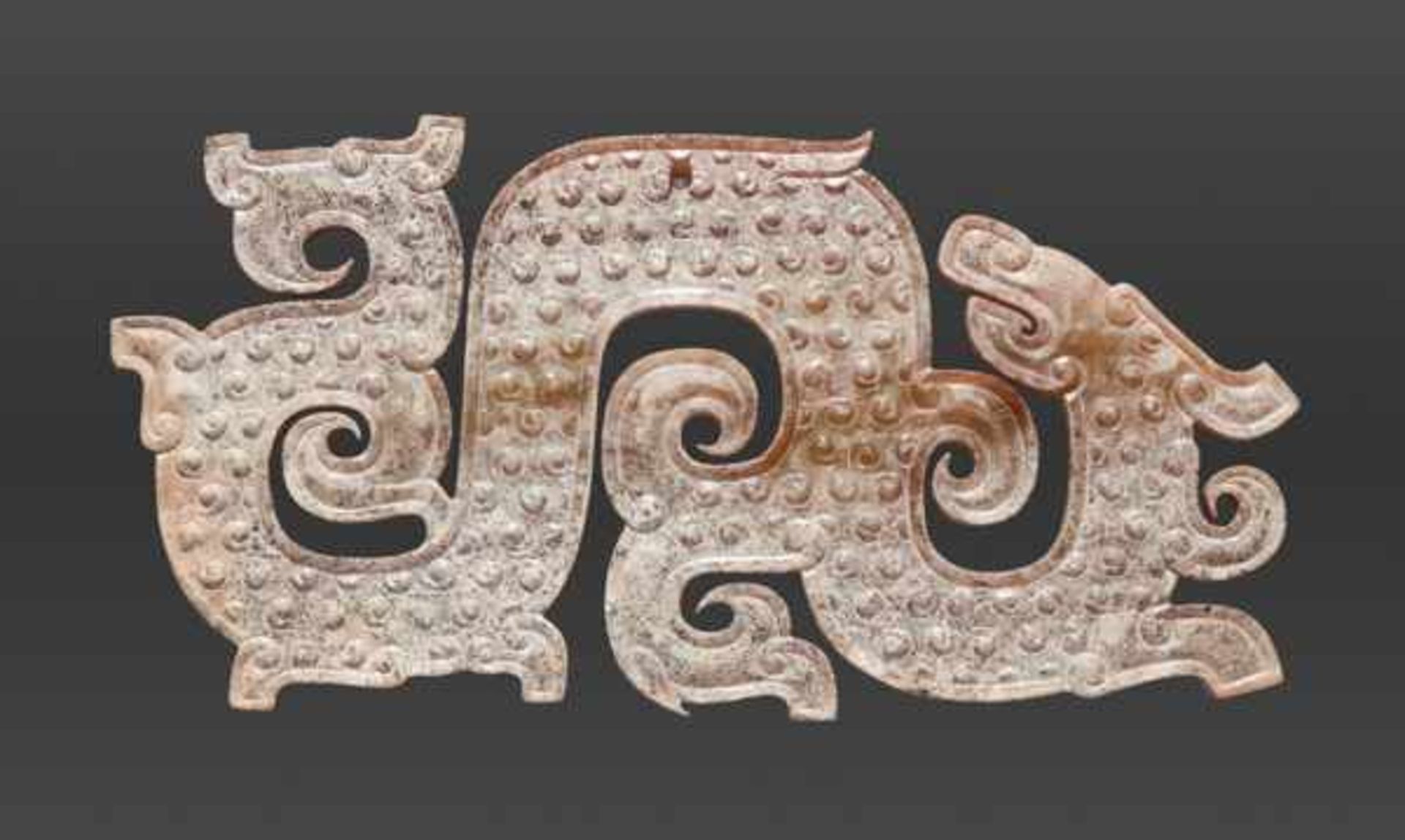 AN ELABORATE DRAGON-SHAPED PENDANT WITH CURLED APPENDAGES Jade, China. Eastern Zhou, 5th - 4th