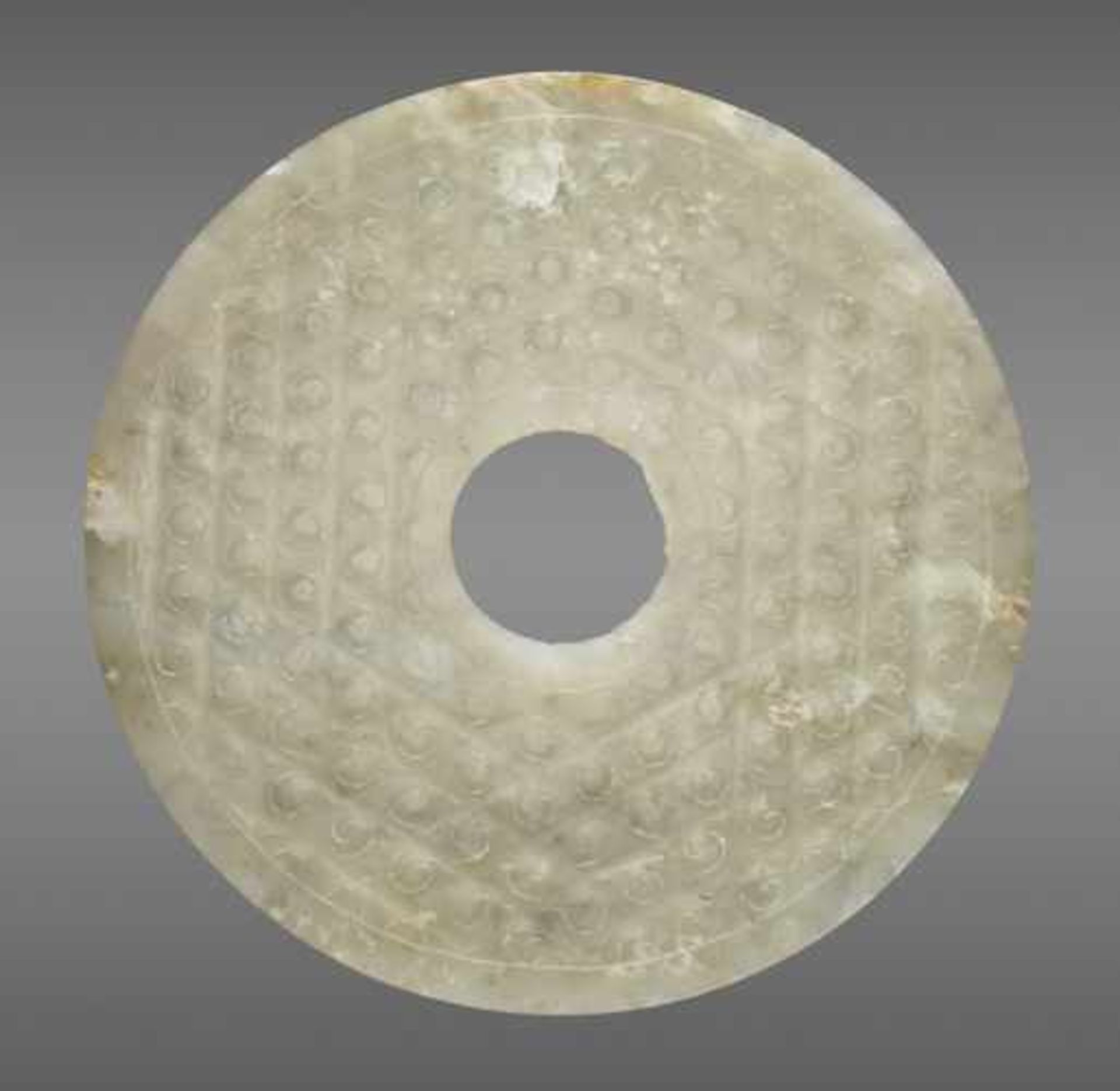 A TRANSLUCENT PALE GREEN DISC DECORATED WITH A PATTERN OF INCISED SPIRALS Jade, China. Western Han - Image 2 of 6