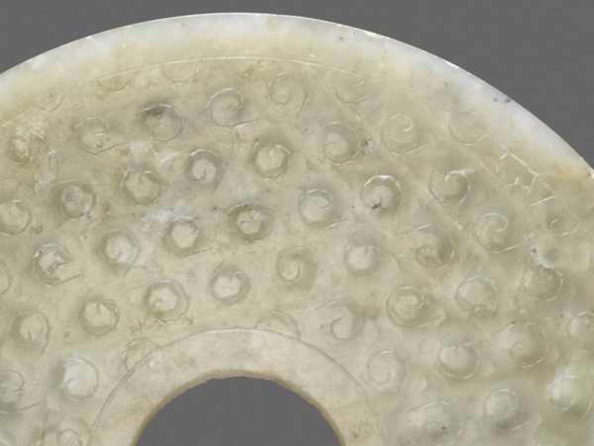 A TRANSLUCENT PALE GREEN DISC DECORATED WITH A PATTERN OF INCISED SPIRALS Jade, China. Western Han - Image 3 of 6