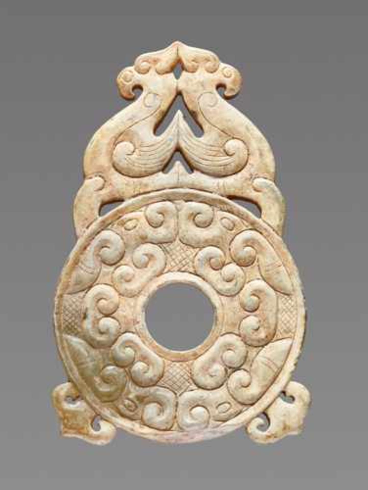 AN ATTRACTIVE SMALL DISC ORNAMENT EMBELLISHED WITH OPENWORK PHOENIXES ON TOP Jade, China. Eastern