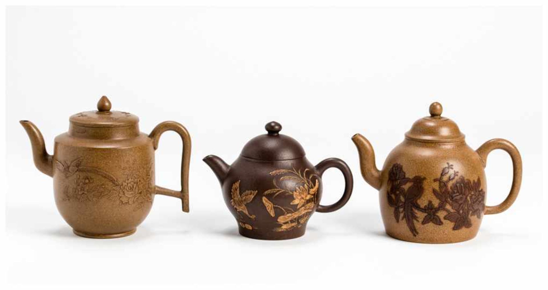 THREE YIXING CERAMIC TEA POTS Yixing ceramic. China, Qing dynastyAll with handles, lids and