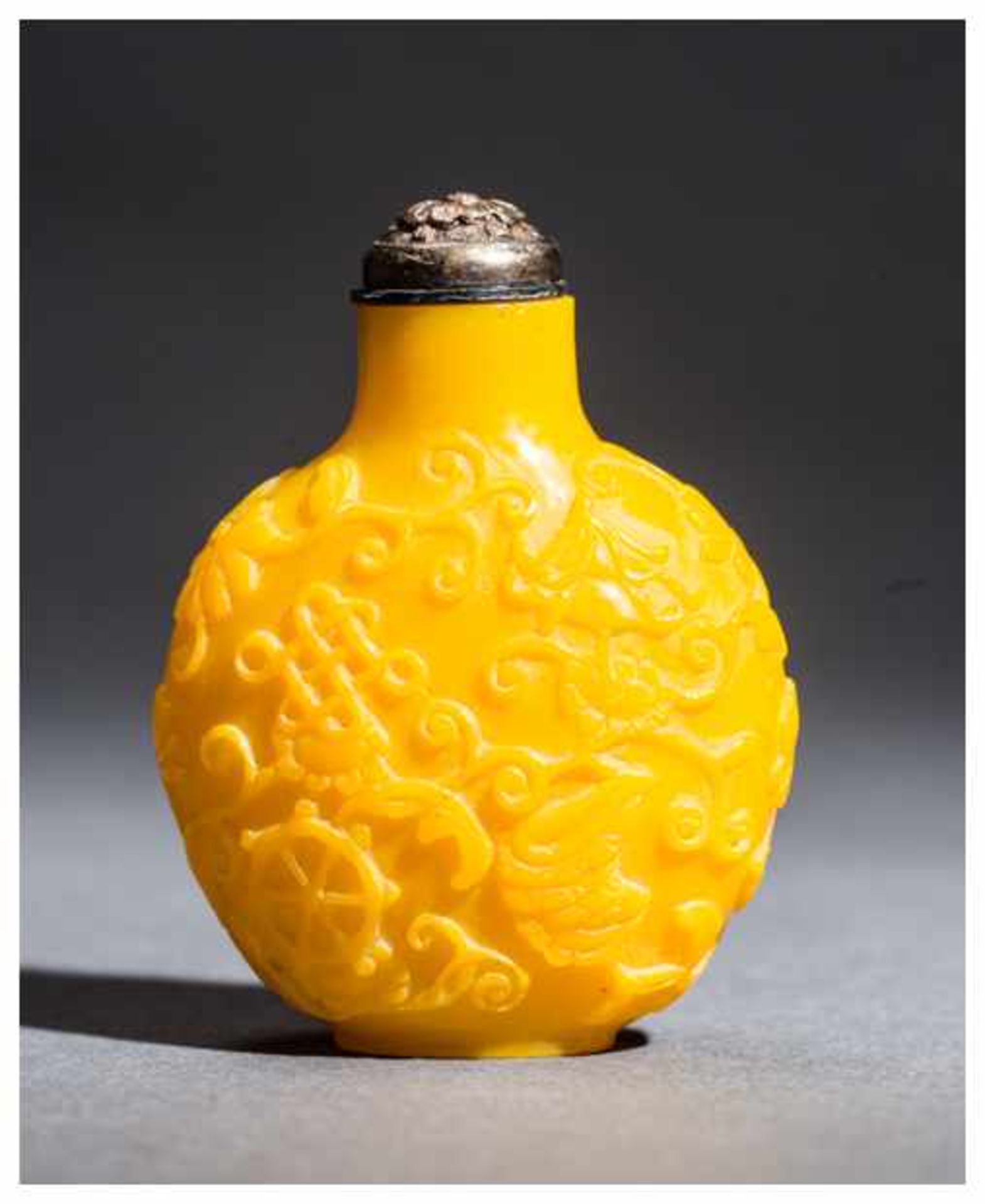 SNUFF BOTTLE WITH THE EIGHT BUDDHIST EMBLEMS Imperial yellow glass. China, 20th centuryThis round