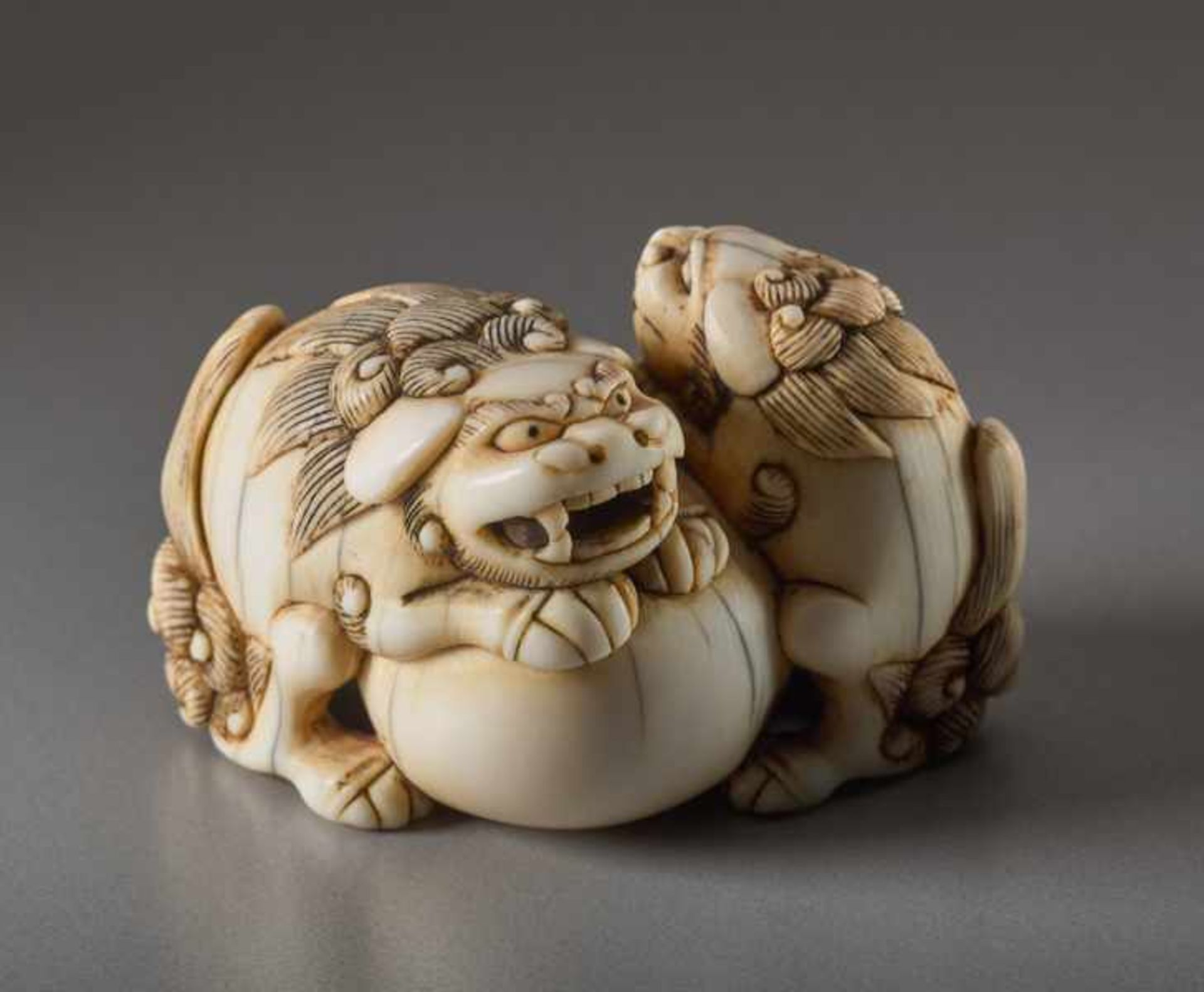 AN IVORY NETSUKE OF TWO SHISHI AND BALL Ivory netsuke. Japan, 18th centuryThe lion dog has a movable