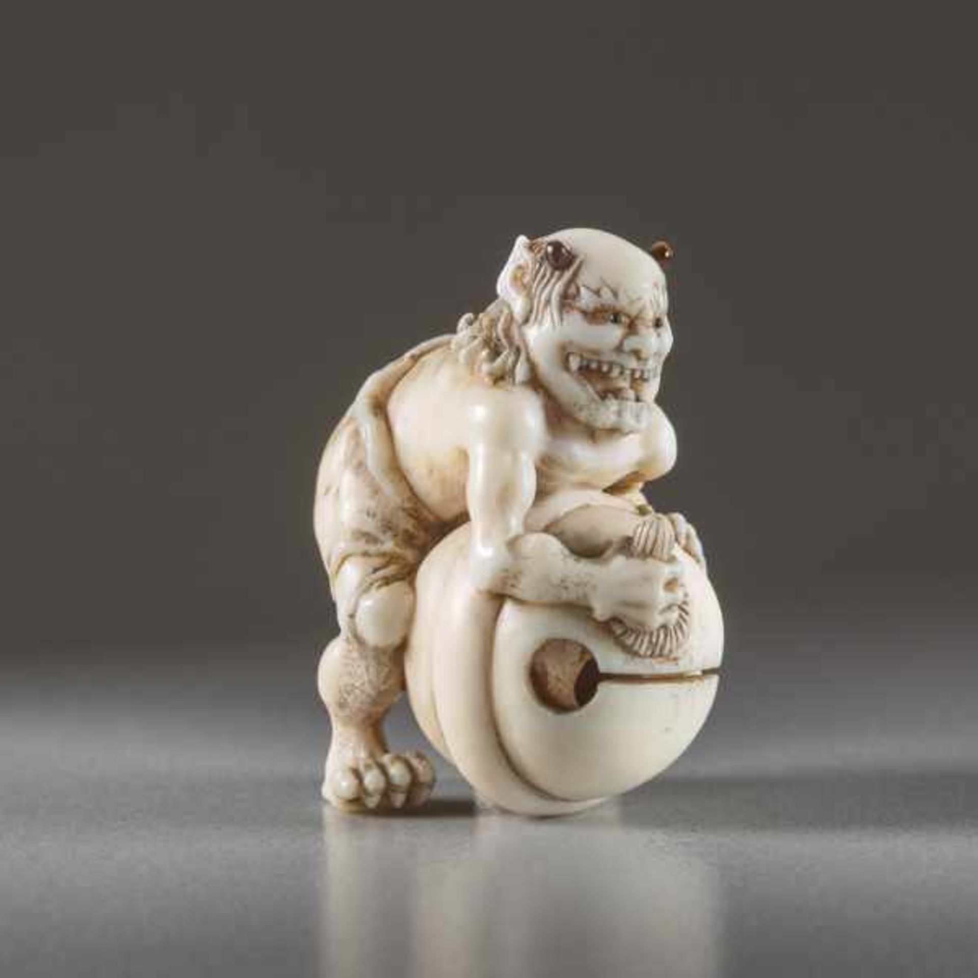 IVORY NETSUKE BY TOMOMASA OF AN ONI Ivory netsuke. Japan, mid-19th centuryA very humorous - Image 2 of 6