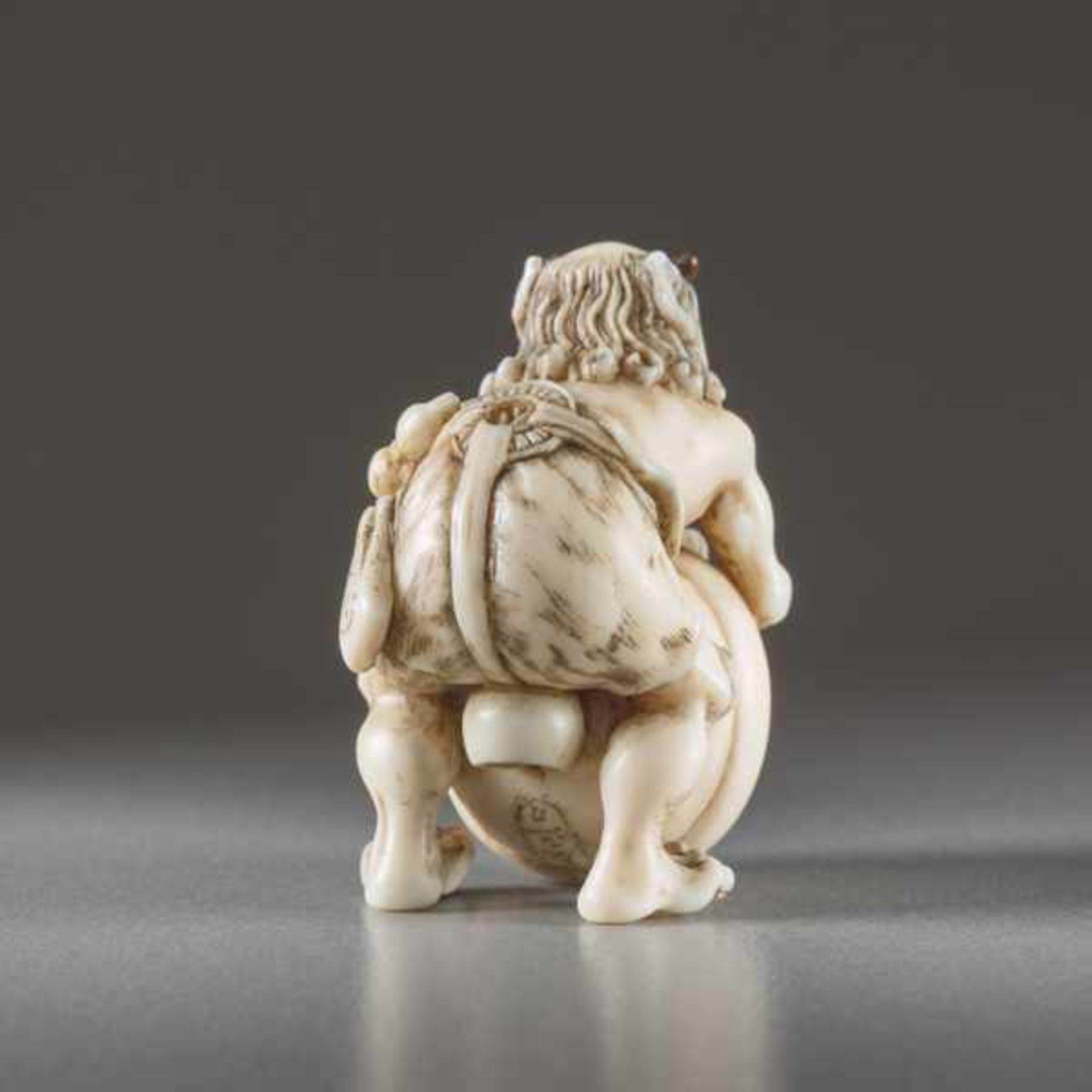 IVORY NETSUKE BY TOMOMASA OF AN ONI Ivory netsuke. Japan, mid-19th centuryA very humorous - Image 4 of 6