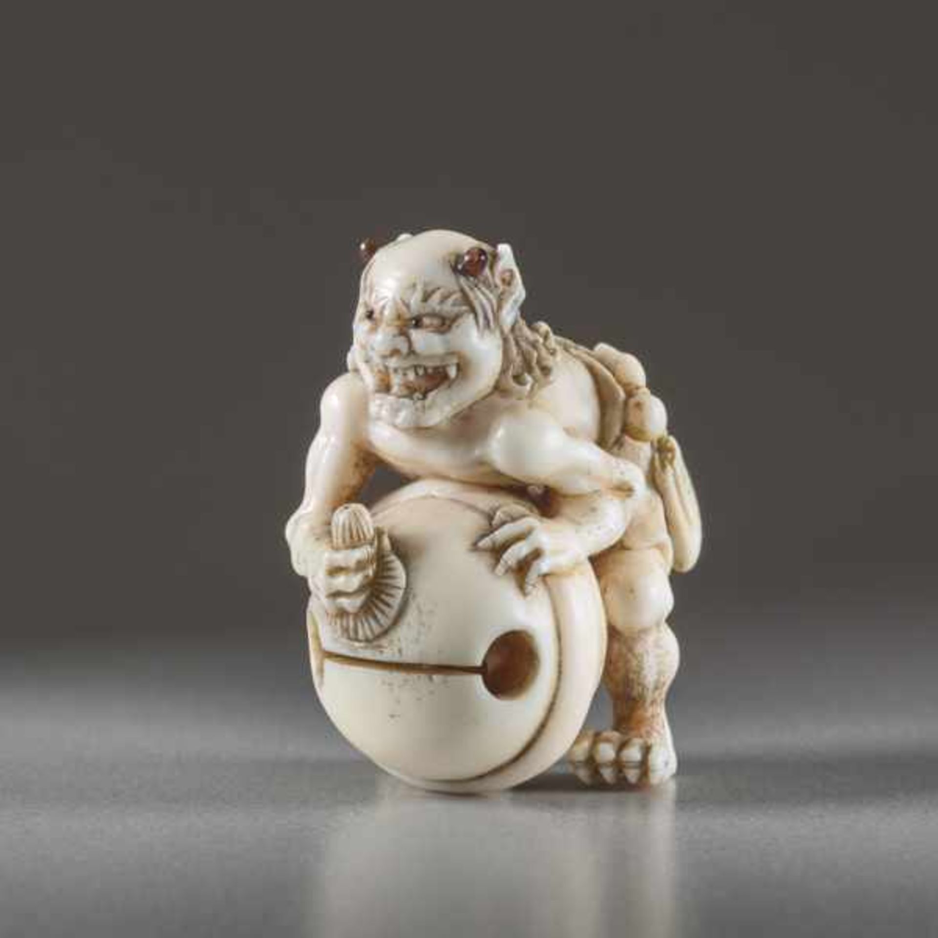 IVORY NETSUKE BY TOMOMASA OF AN ONI Ivory netsuke. Japan, mid-19th centuryA very humorous