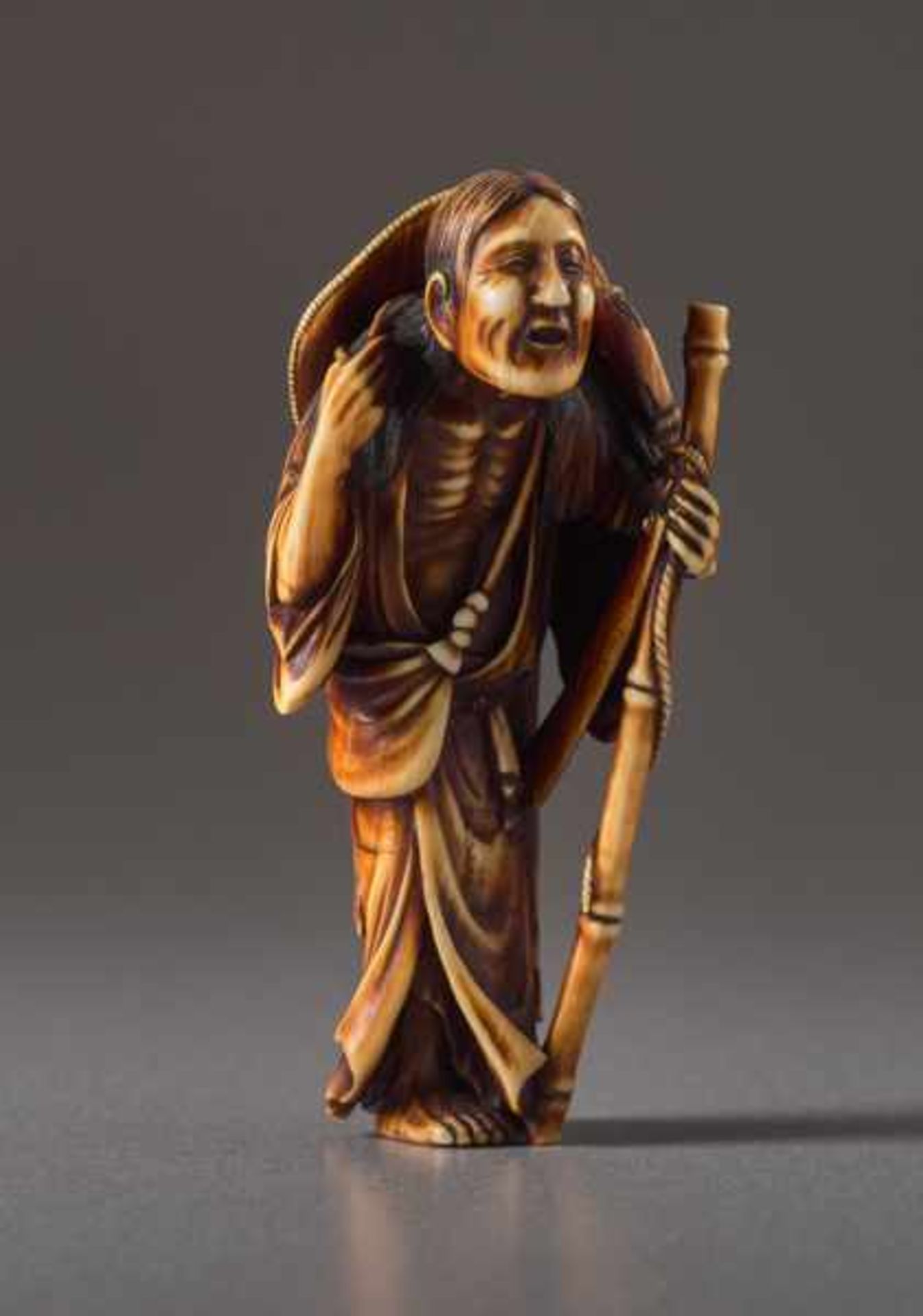 AN IVORY NETSUKE BY SORAKU OF THE POET KOMACHI AS AN OLD WOMAN Ivory netsuke. Japan, 19th centuryA