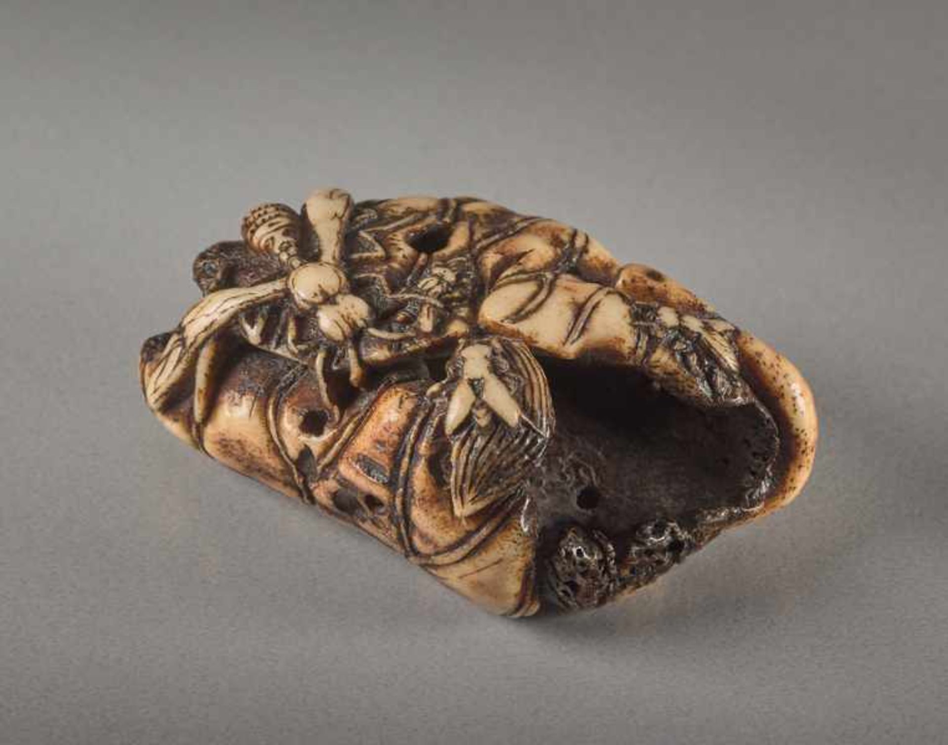 A STAG ANTLER NETSUKE BY SHUNMIN OF A LOTUS LEAF AND INSECTS Stag antler netsuke. Japan, first