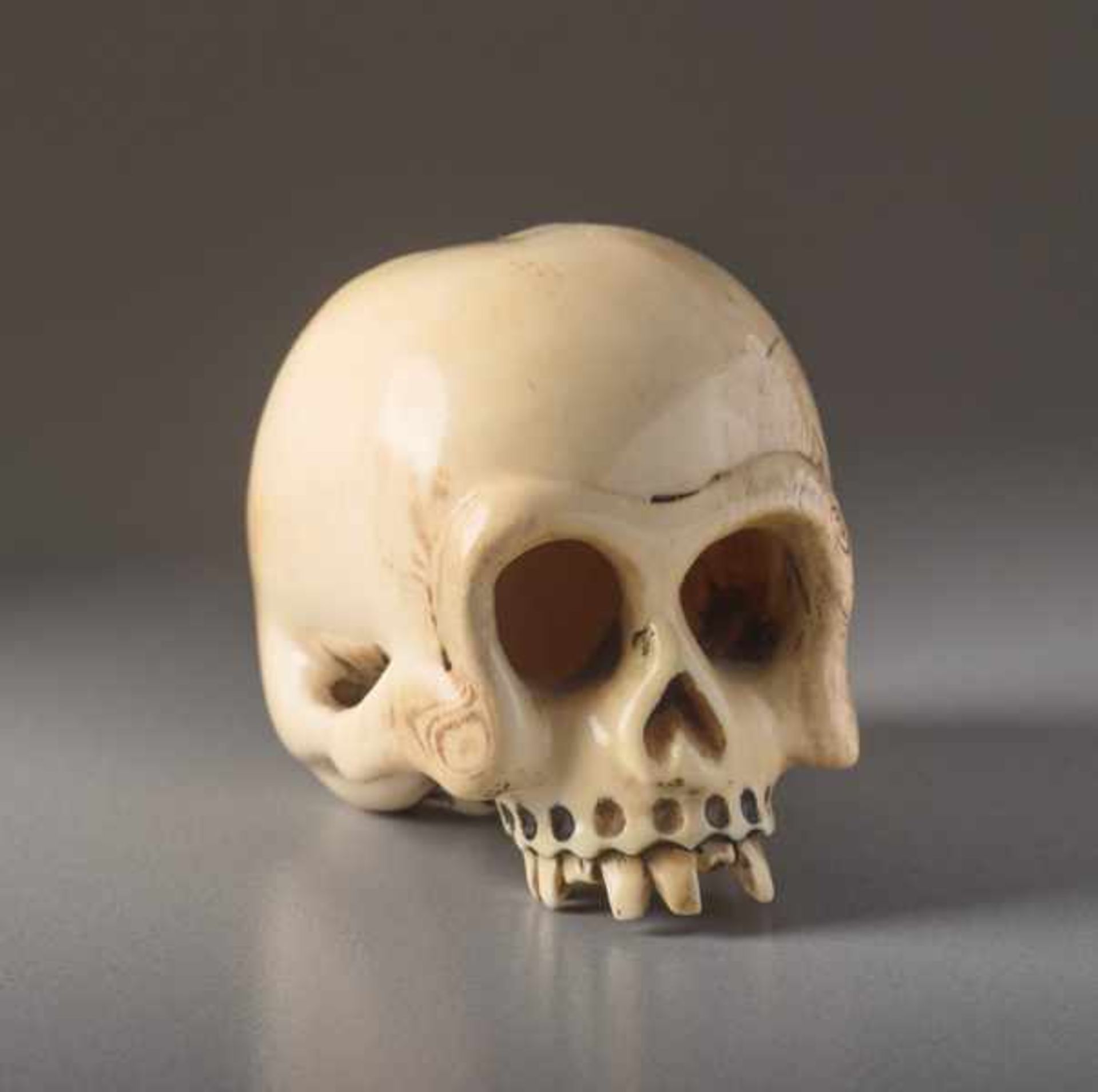 AN IVORY NETSUKE BY SHOZAN OF A SKULL Ivory netsuke. Japan, 19th centuryAn excellently crafted,