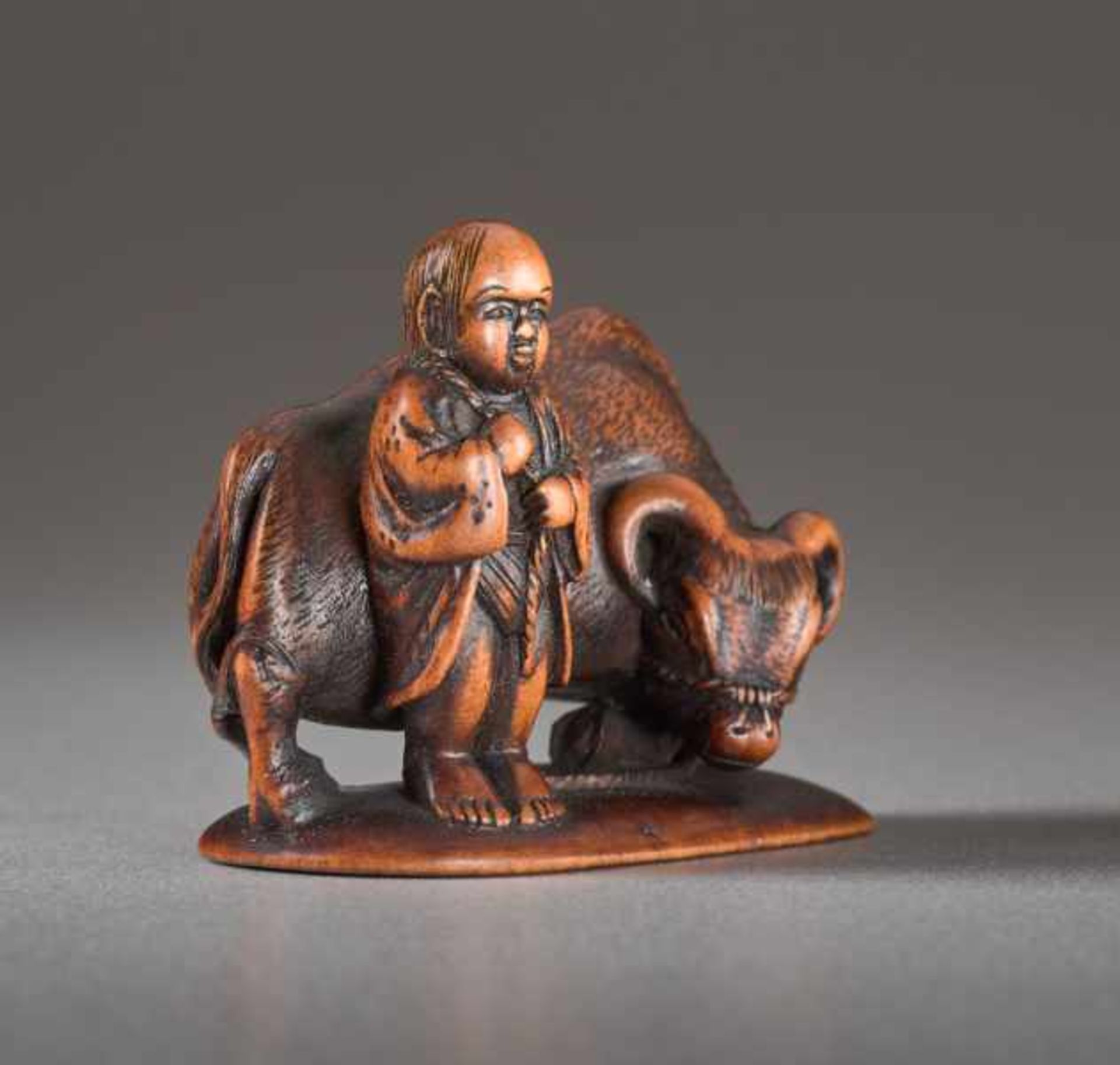 A WOOD NETSUKE BY MINKOKU OF A BOY AND OX Wood netsuke. Japan, 19th centuryA brawny ox with curved - Image 3 of 5