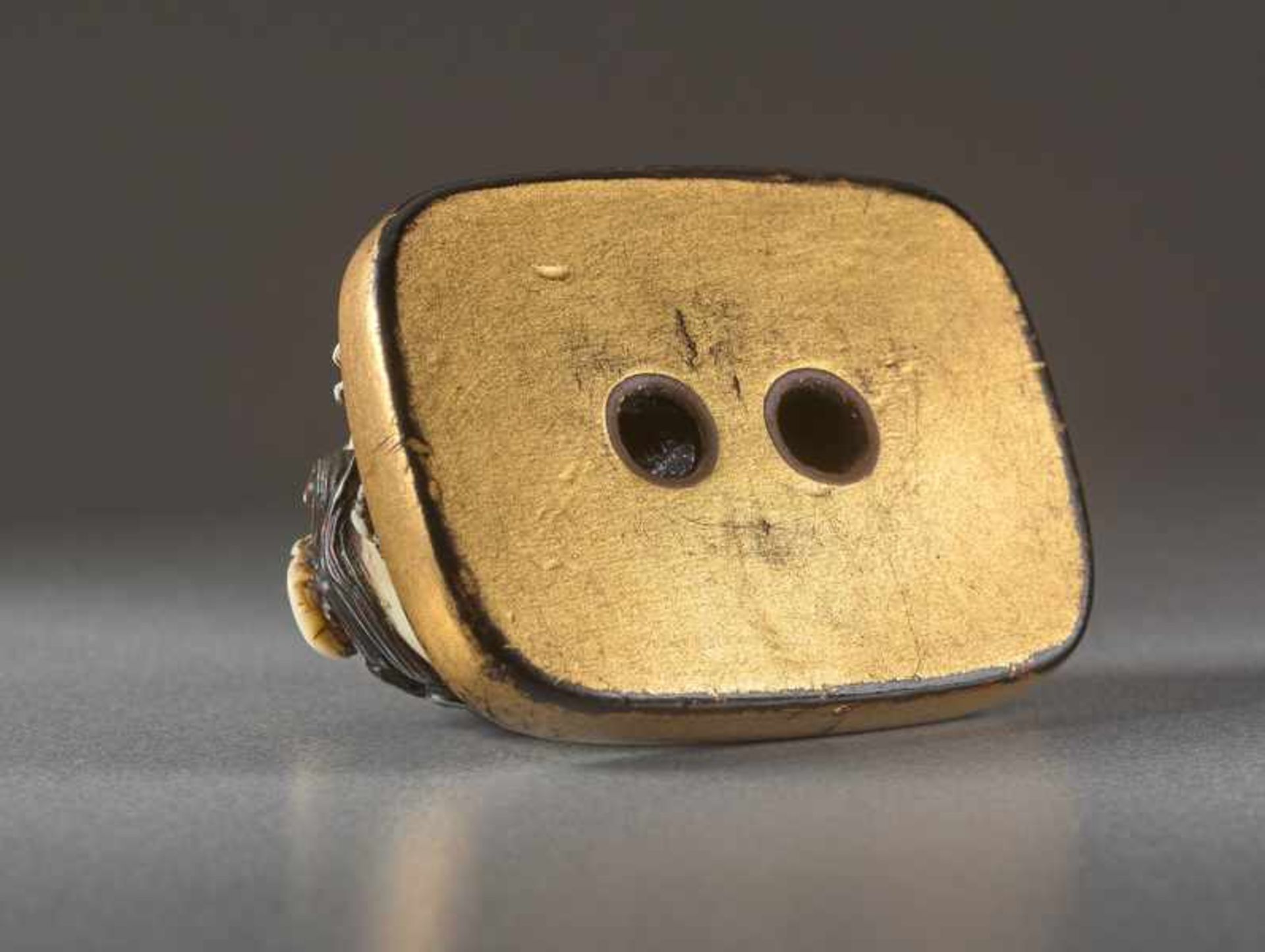 AN IVORY AND LACQUER NETSUKE OF A RECUMBENT SHISHI ON MAT Ivory netsuke with gold lacquer. Japan, - Image 5 of 5