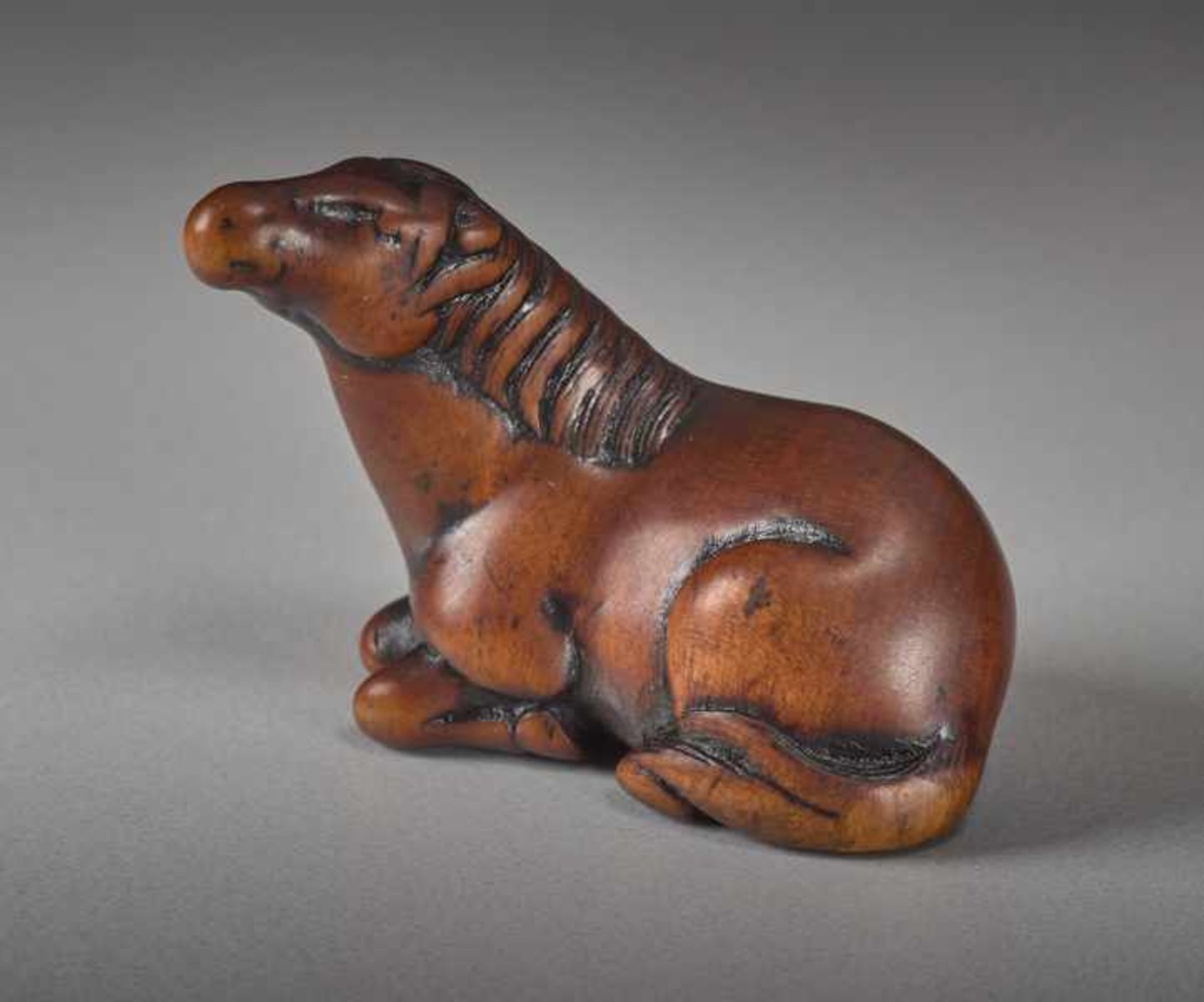 A WOOD NETSUKE OF A RECUMBENT HORSE Wood netsuke. Japan, first half of 19th centuryA very perceptive