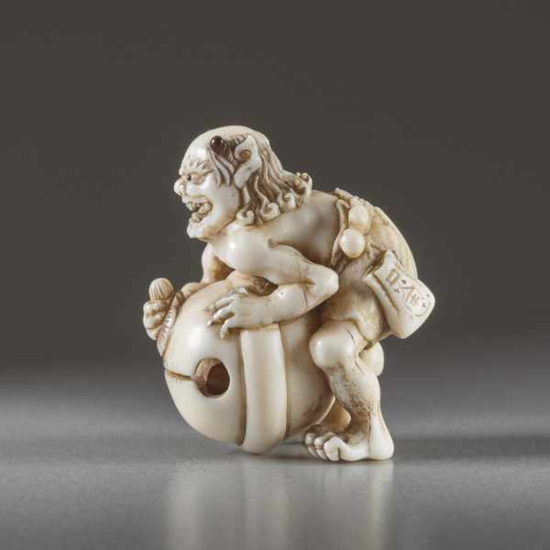 IVORY NETSUKE BY TOMOMASA OF AN ONI Ivory netsuke. Japan, mid-19th centuryA very humorous - Image 3 of 6