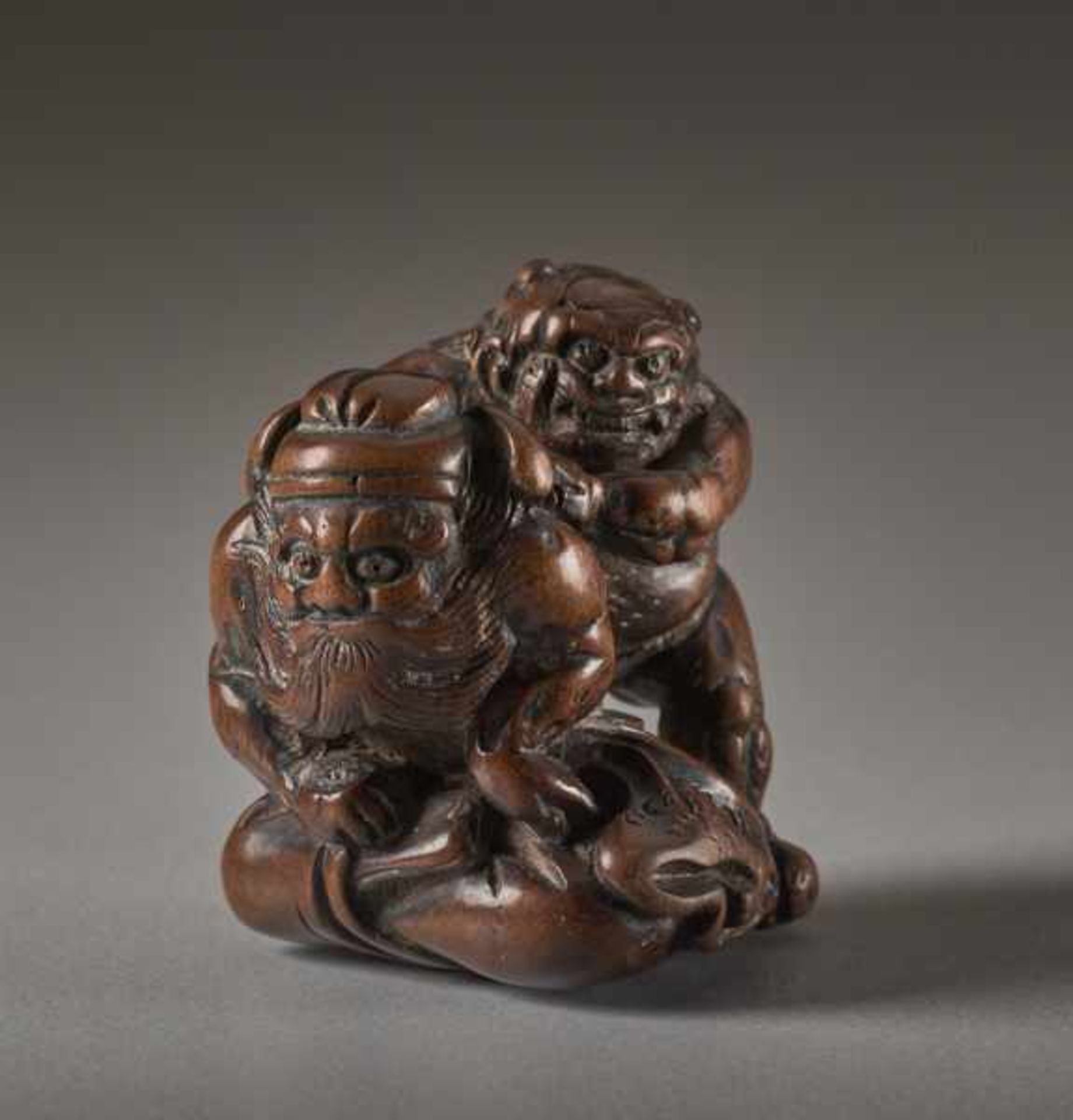 A WOOD NETSUKE OF THE DEMON QUELLER SHOKI WITH ONI Wood netsuke. Japan, 19th centuryThe famous