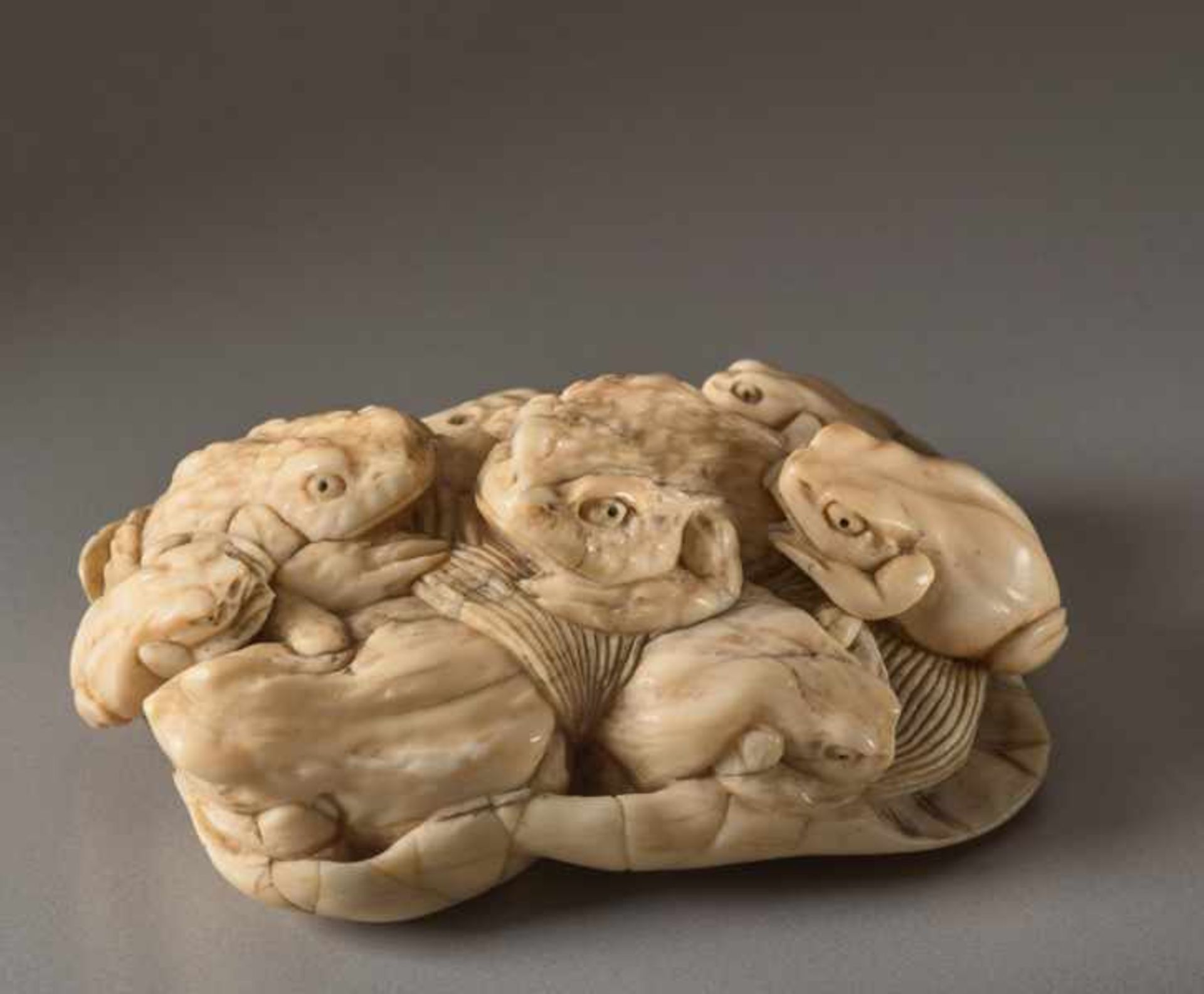 AN IVORY OKIMONO OF TOADS ON A LOTUS LEAF Ivory okimono. Japan, Meiji periodThe toad (gama) is a