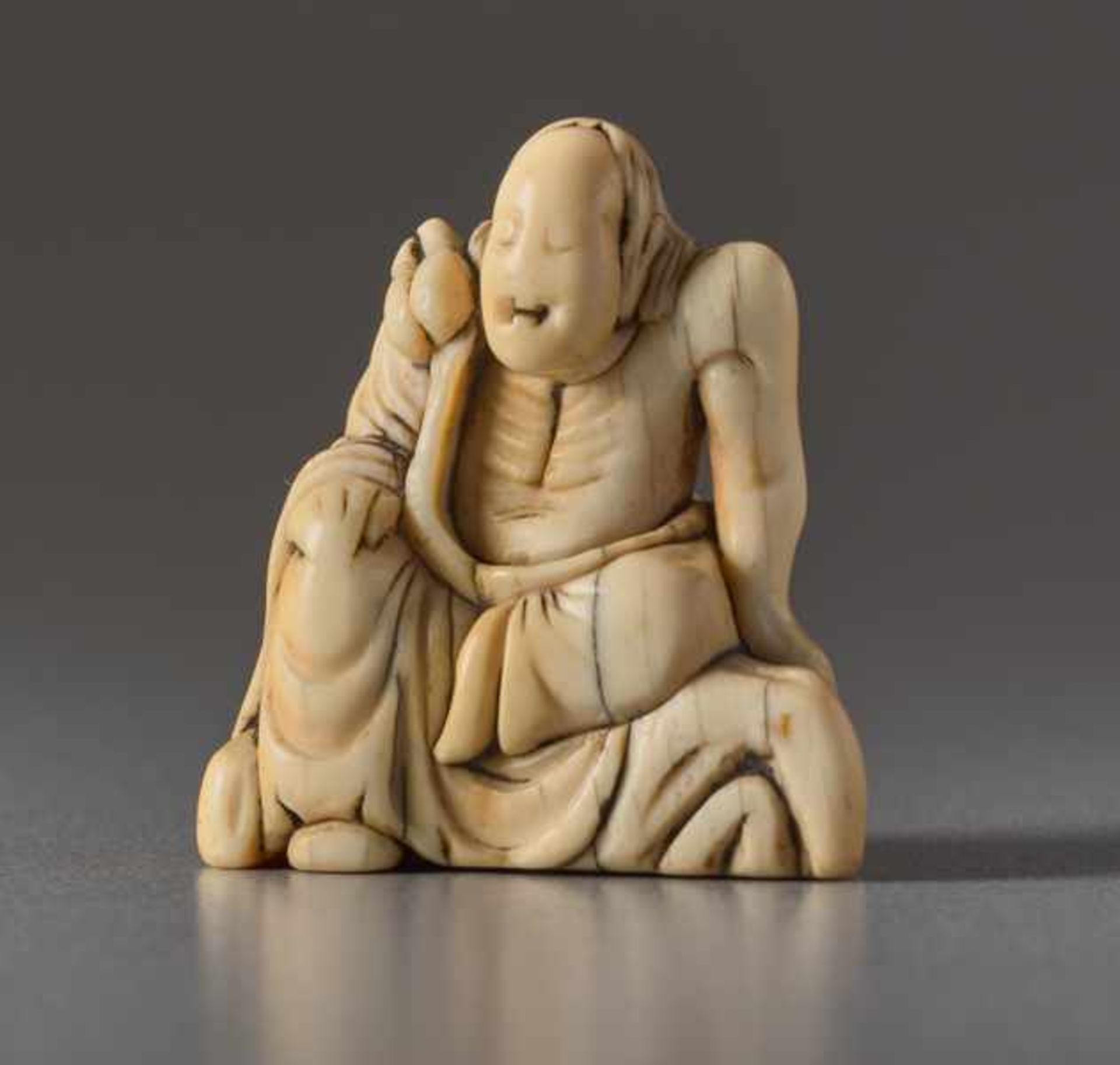 AN IVORY NETSUKE OF AN IMMORTAL ON A ROCK Ivory netsuke. Japan, 18th centuryLarge head of a wise