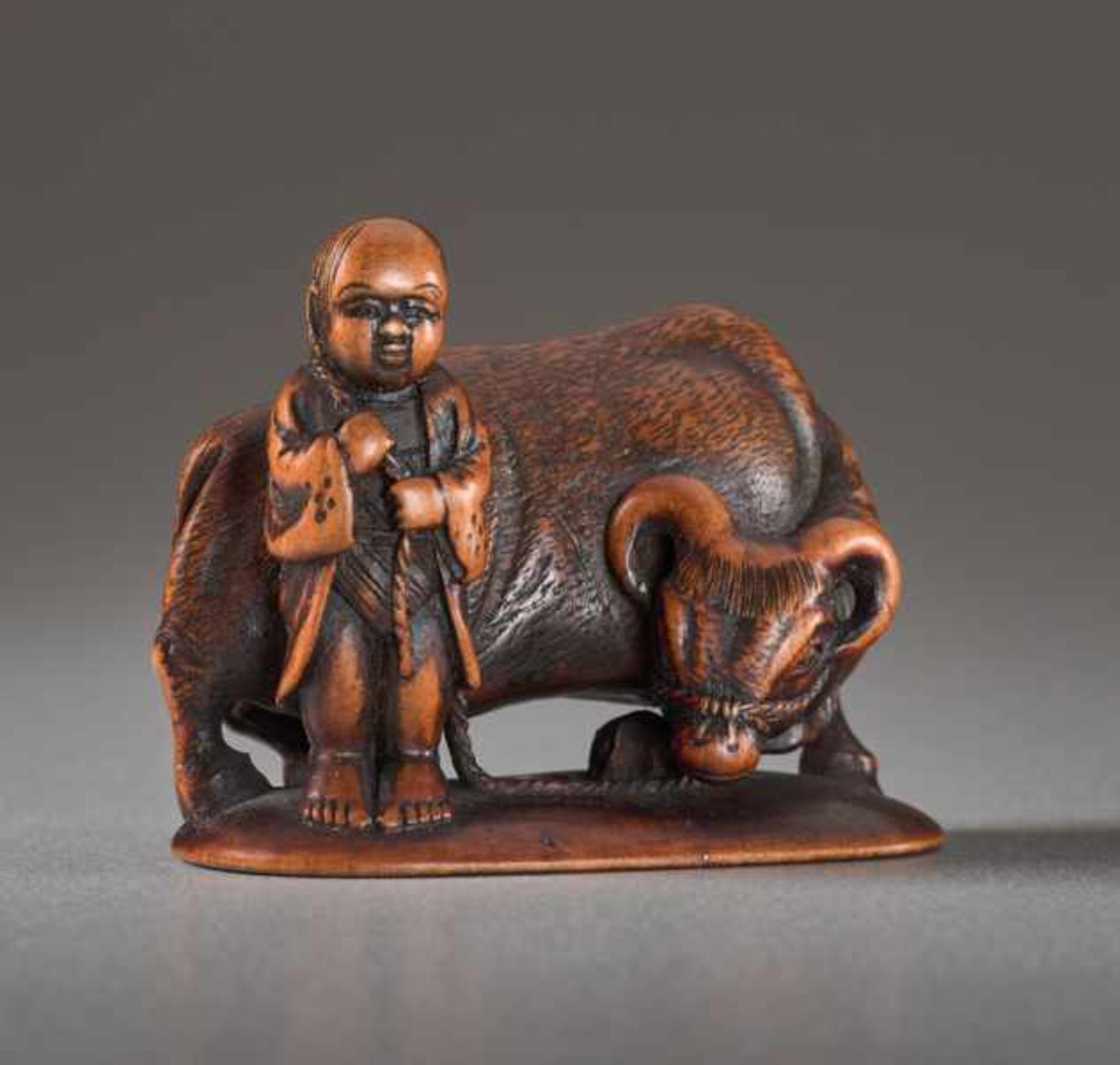 A WOOD NETSUKE BY MINKOKU OF A BOY AND OX Wood netsuke. Japan, 19th centuryA brawny ox with curved - Image 2 of 5