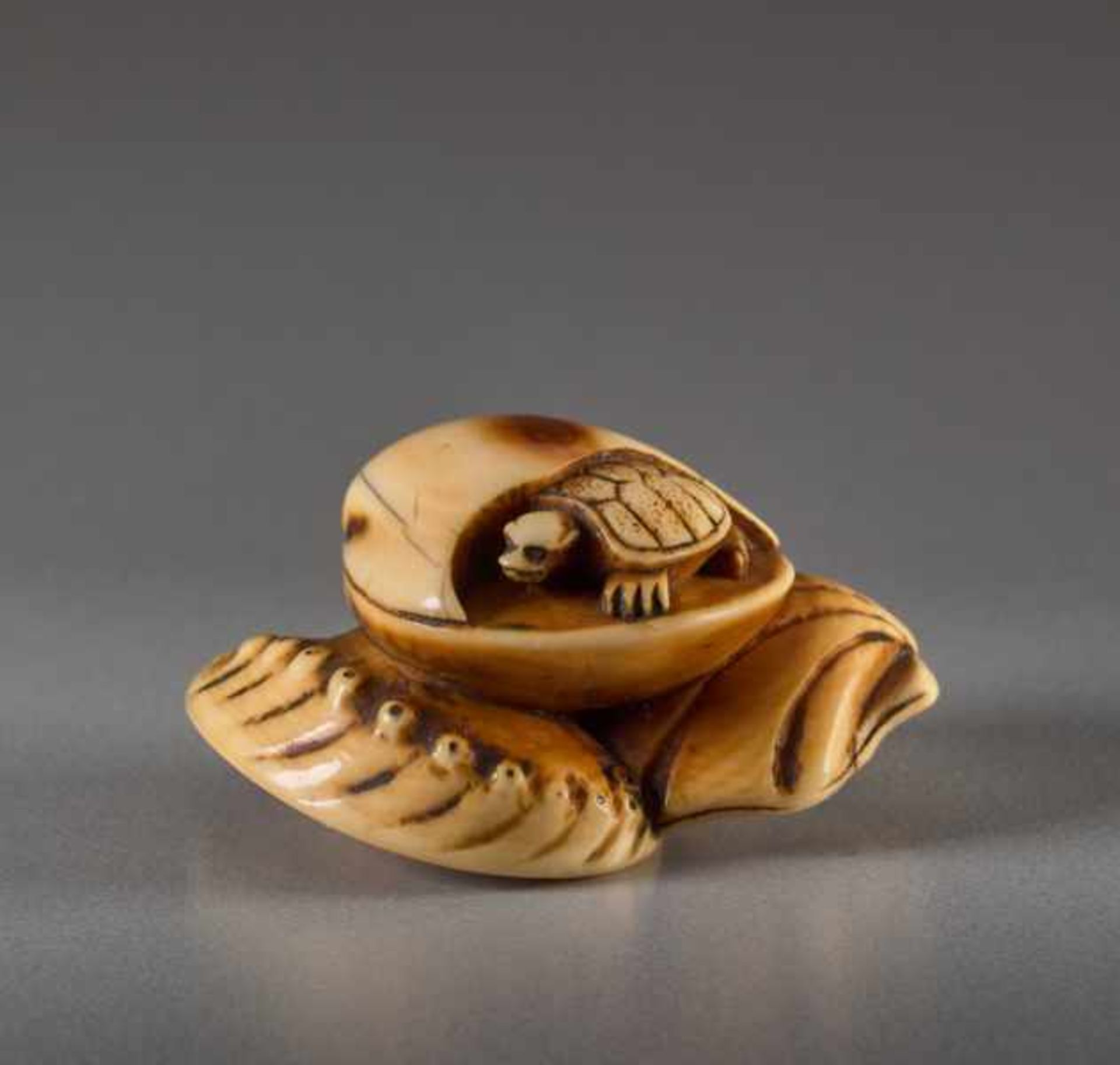 AN IVORY NETSUKE OF CLAMS AND MINOGAME Ivory netsuke. Japan, early 19th centuryA very finely crafted