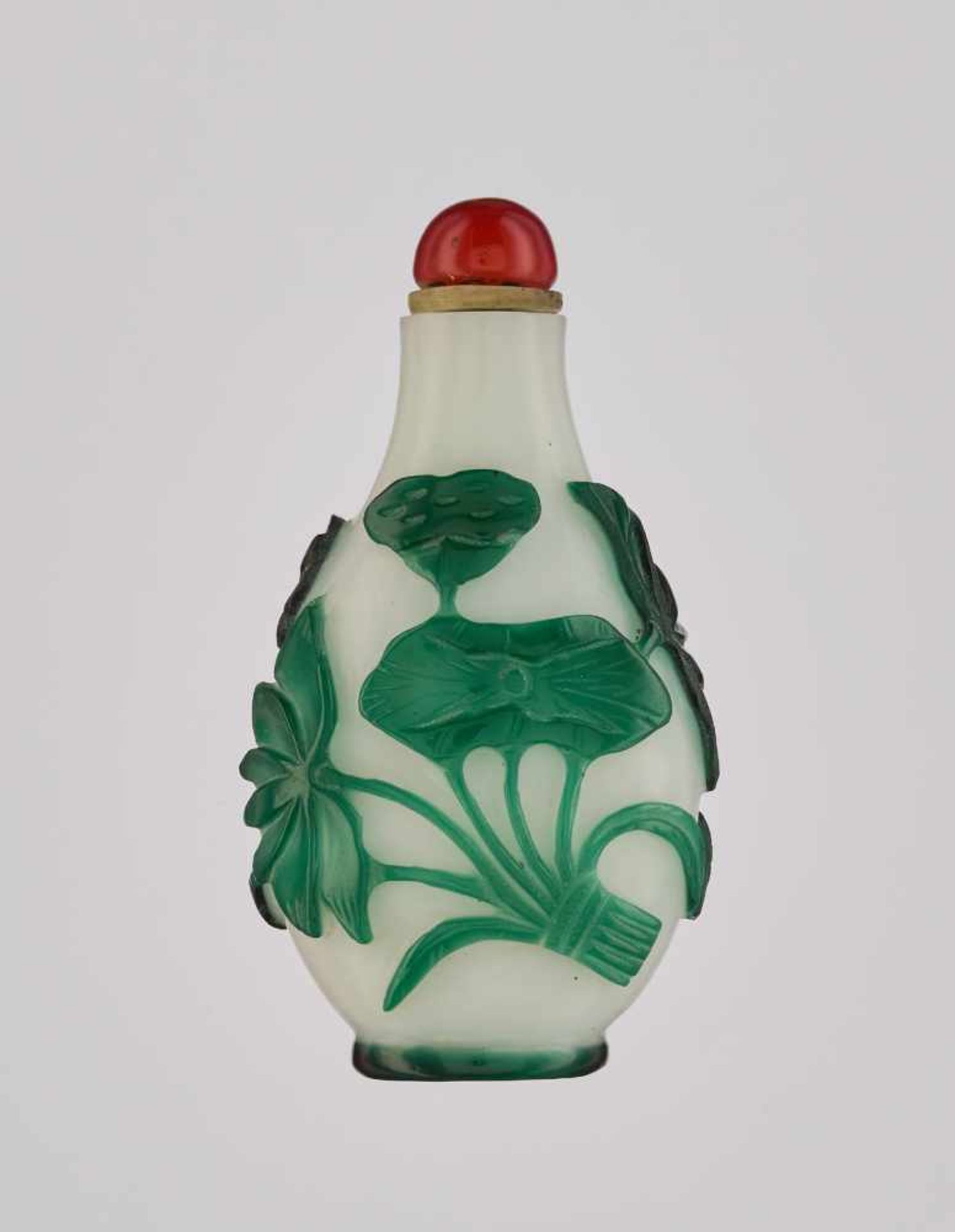 AN EMERALD-GREEN OVERLAY WHITE GLASS ‘LOTUS’ SNUFF BOTTLE, QING DYNASTY Glass, with incised