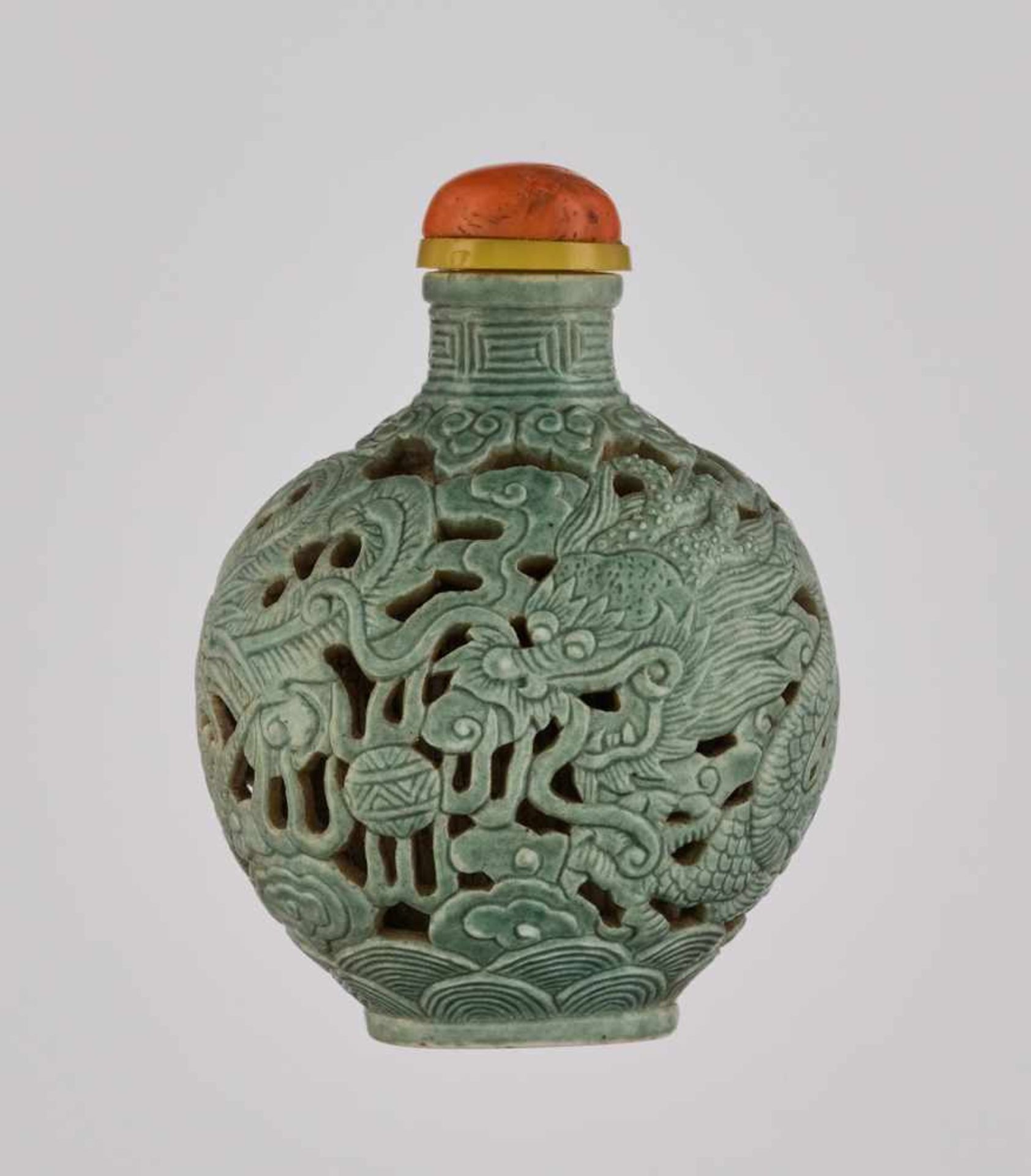 A RETICULATED TURQUOISE-GLAZED ‘DRAGON & PHOENIX’ PORCELAIN SNUFF BOTTLE Molded and carved porcelain