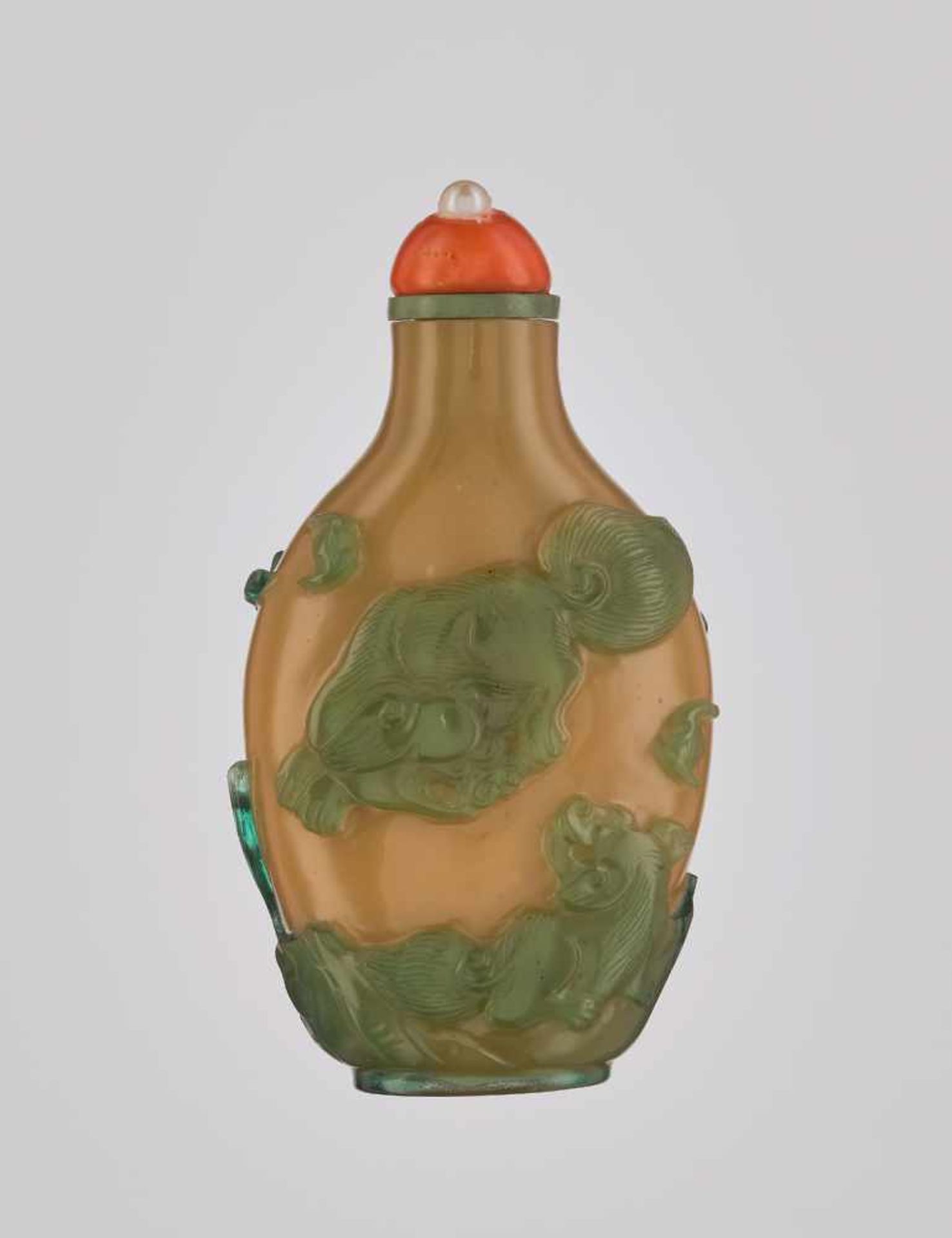 A CARAMEL-BROWN AND GREEN ‘BUDDHIST LION & CARPS’ OVERLAY GLASS SNUFF BOTTLE Carved opaque caramel-