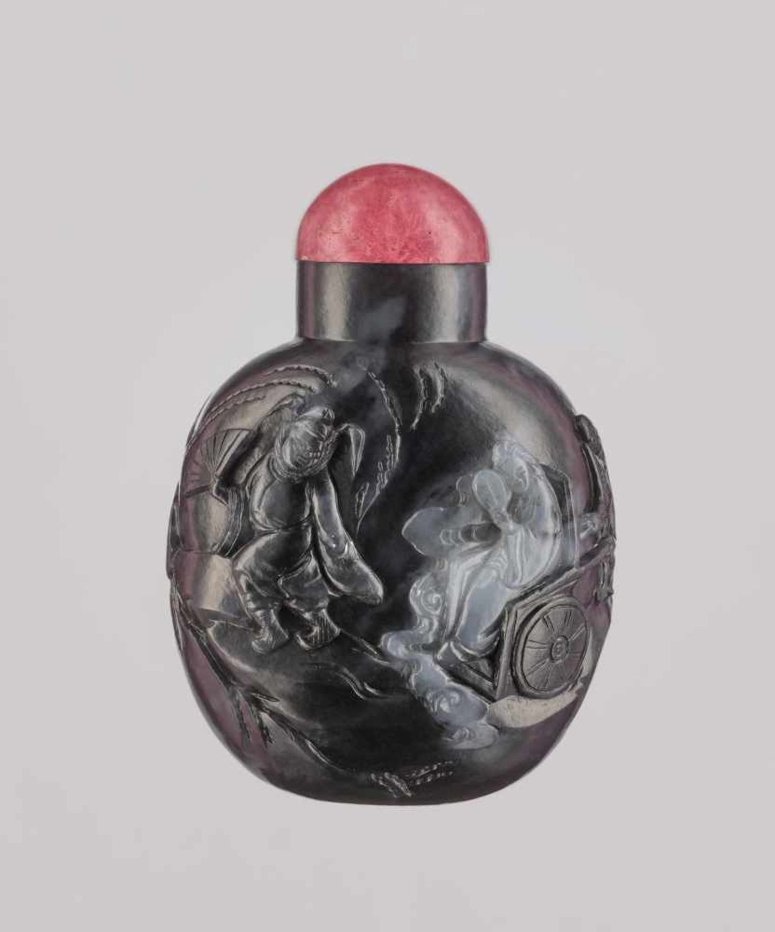 A BLACK AND WHITE ‘ZHONG KUI’ JADE SNUFF BOTTLE, QING DYNASTY Nephrite, carved in high relief,