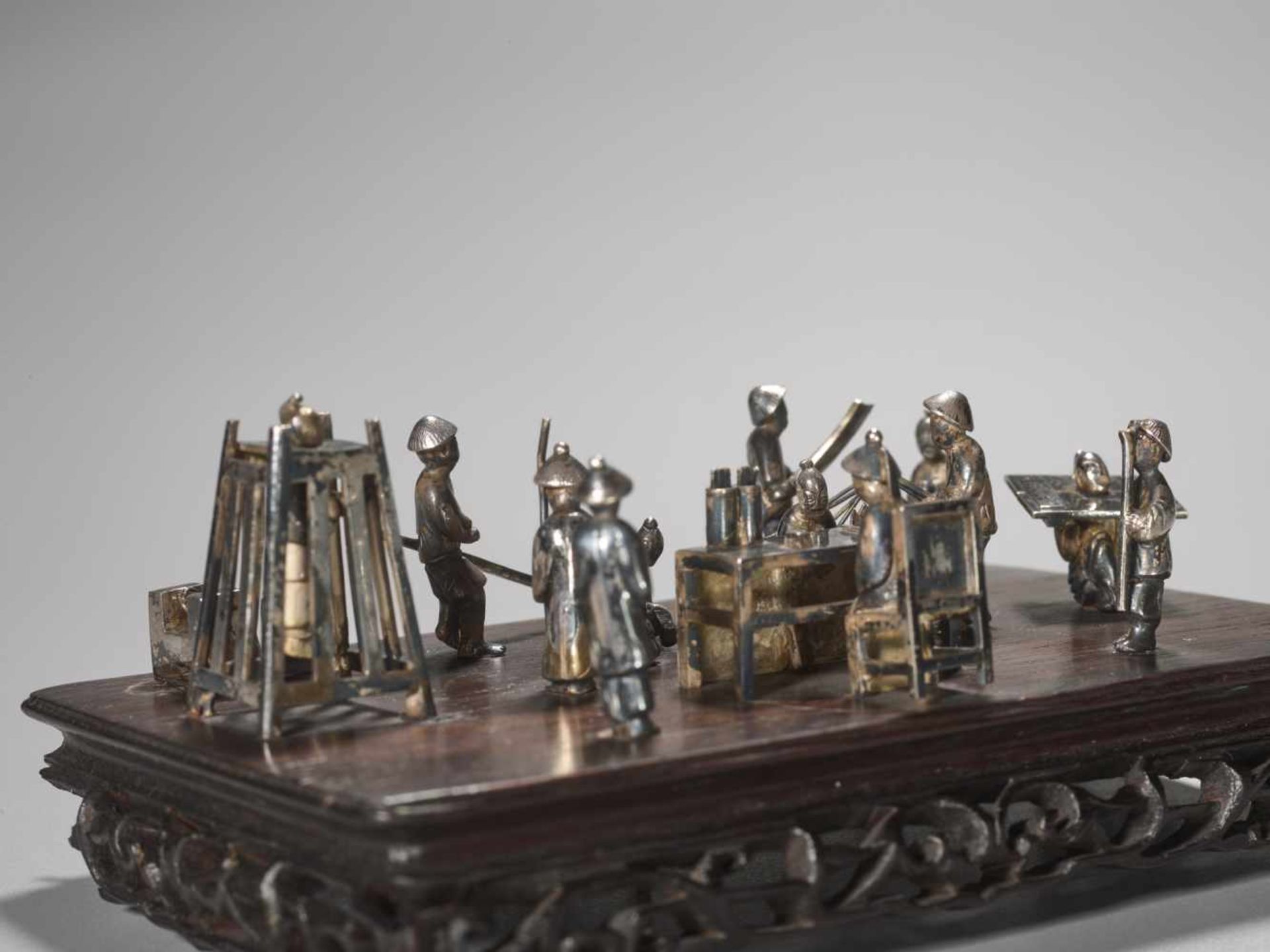 A QING DYNASTY SILVER MINIATURE GROUP ‘MAGISTRATE HOLDING COURT’ Silver and metal, wooden base - Image 8 of 9