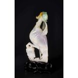 A JADEITE SCULPTURE OF A PHEONIX WITH PEONY, 1900s Jadeite in white, lilac, russet, and green hues
