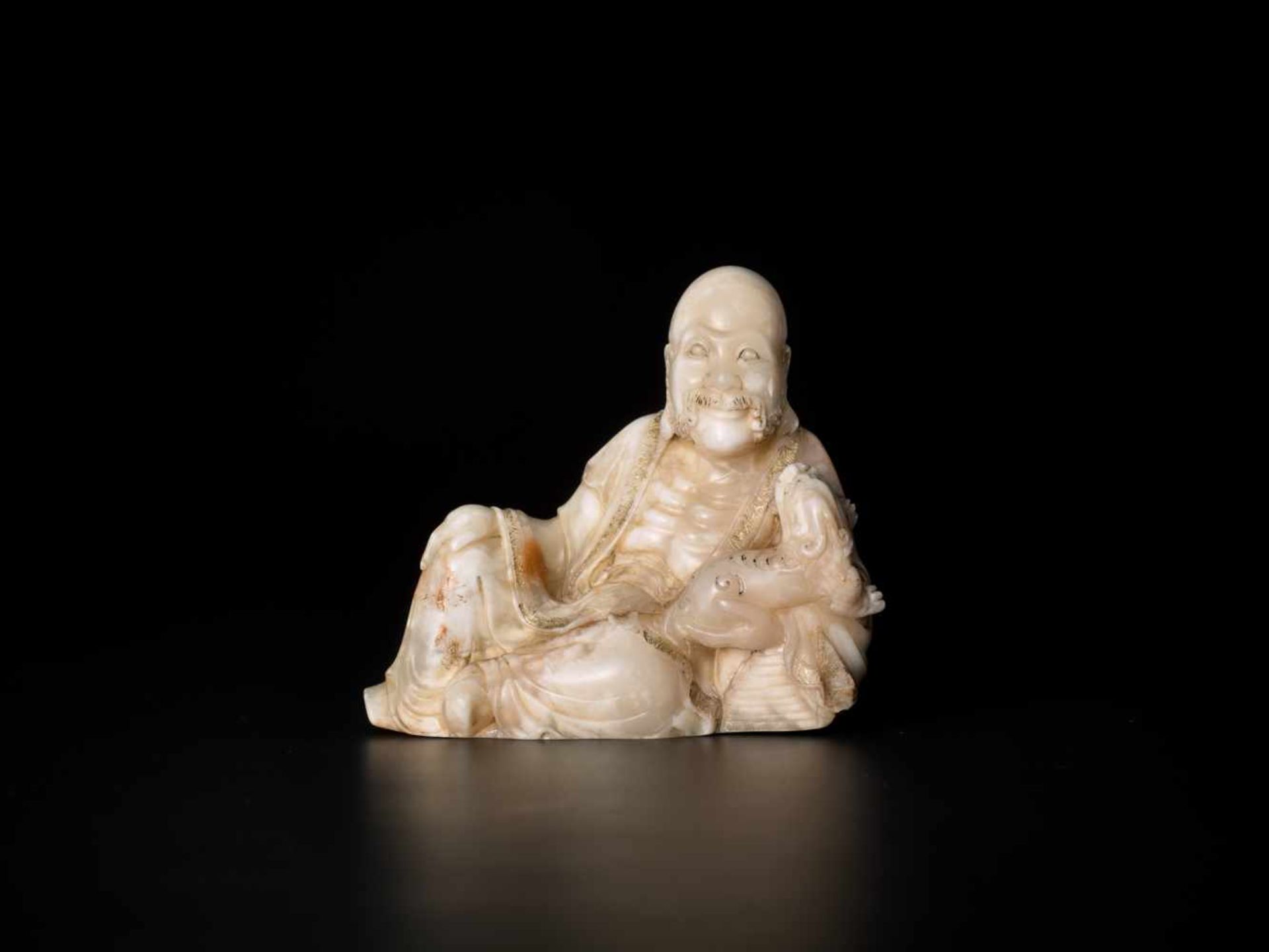 A MASTERLY CARVED 18th CENTURY SOAPSTONE FIGURE OF A LUOHAN WITH QILIN Soapstone of an opaque