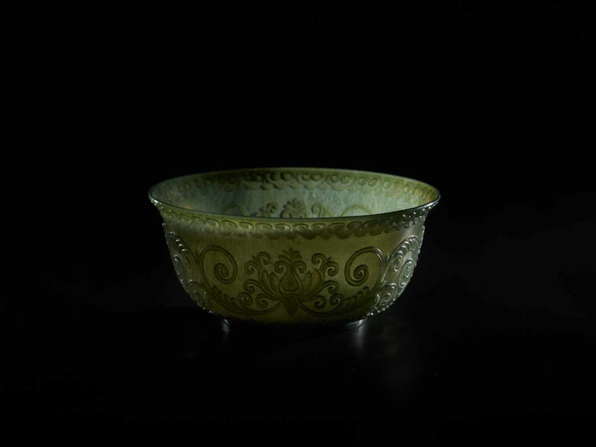 A TRANSLUCENT SPINACH GREEN MUGHAL STYLE ‘LOTUS’ JADE BOWL, QING DYNASTY The jade carved in high