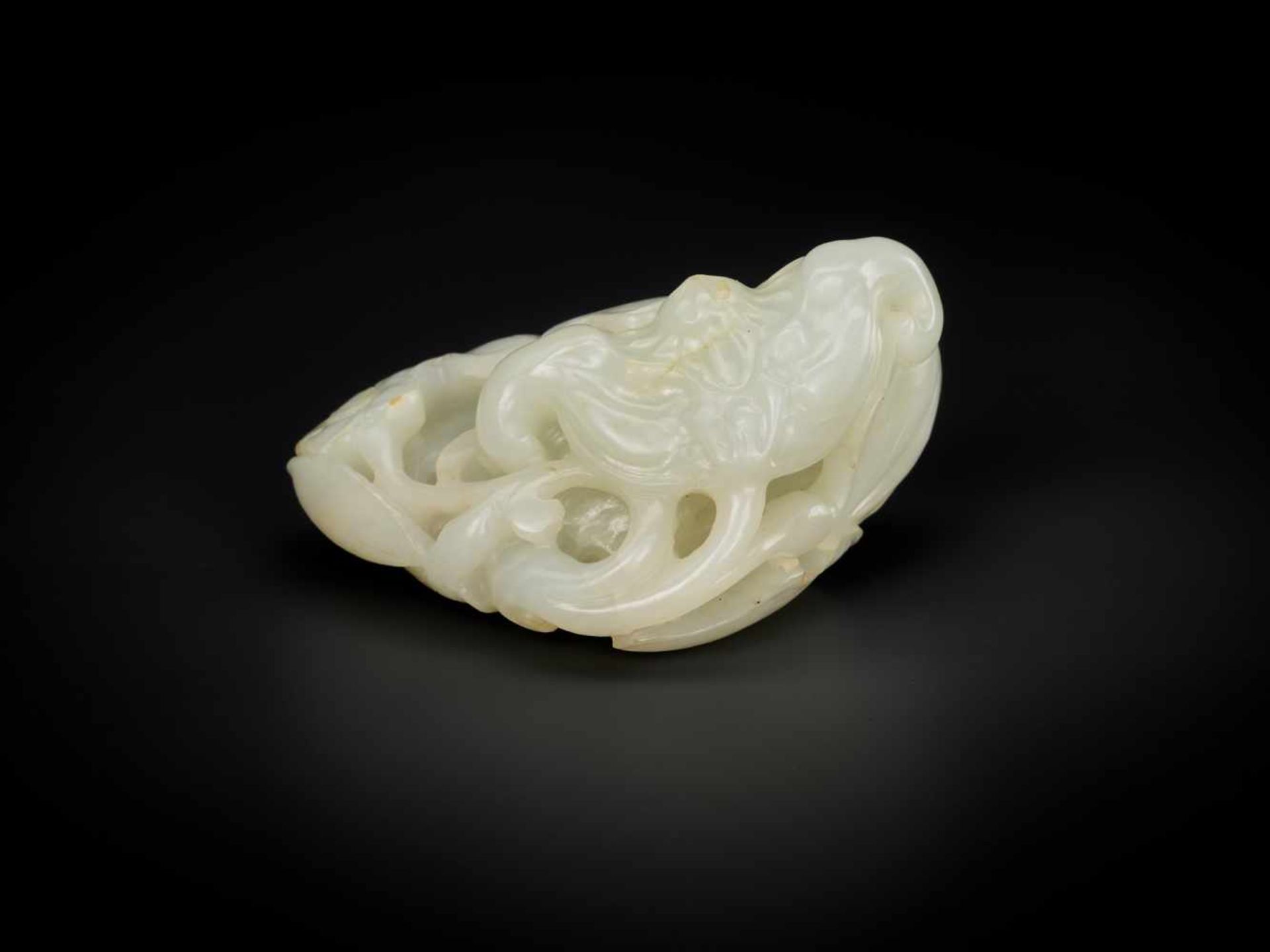 A QING DYNASTY WHITE AND RUSSET JADE ‘BAT AND LOTUS’ GROUP White jade with sparse russet inclusions,