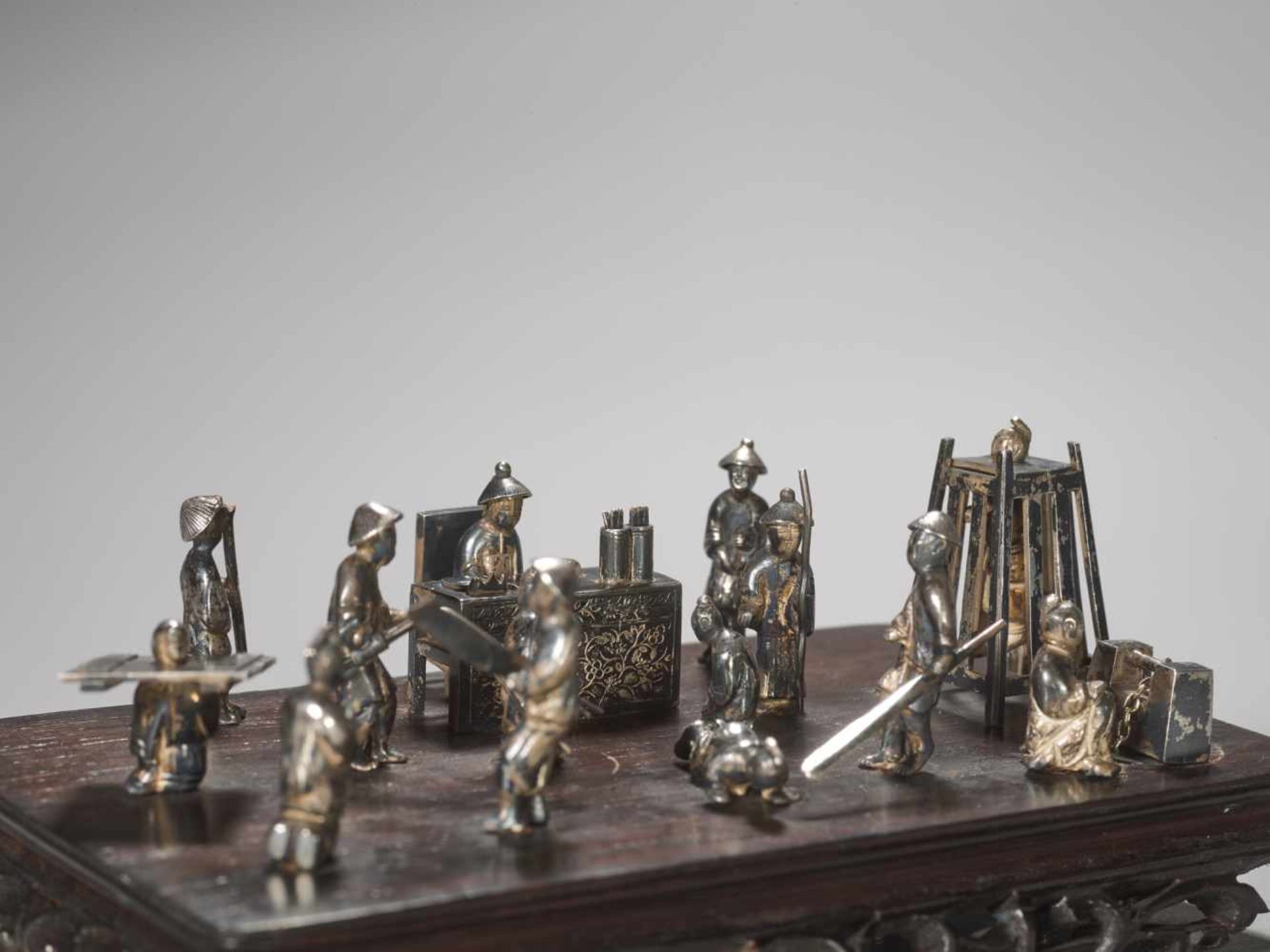 A QING DYNASTY SILVER MINIATURE GROUP ‘MAGISTRATE HOLDING COURT’ Silver and metal, wooden base - Image 6 of 9