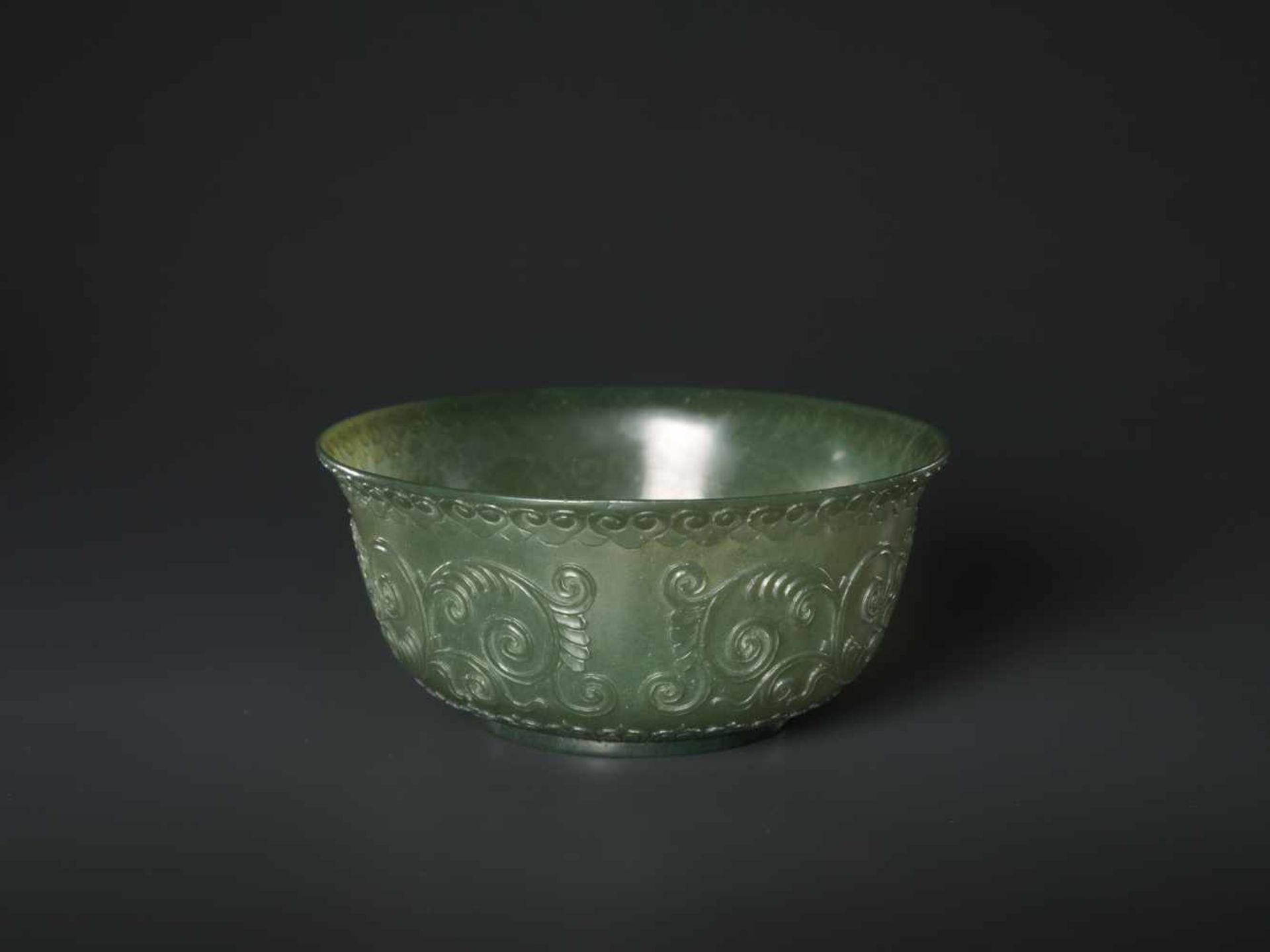 A TRANSLUCENT SPINACH GREEN MUGHAL STYLE ‘LOTUS’ JADE BOWL, QING DYNASTY The jade carved in high - Image 2 of 8