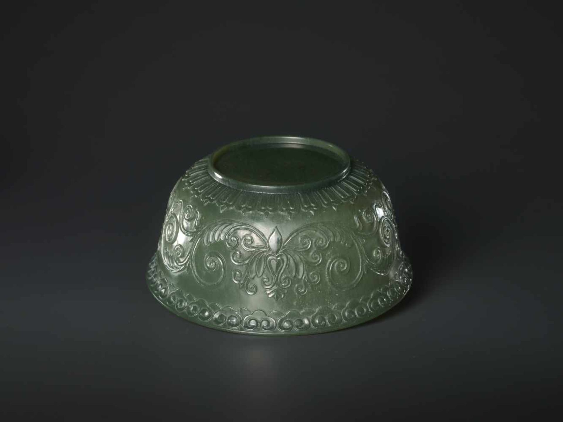 A TRANSLUCENT SPINACH GREEN MUGHAL STYLE ‘LOTUS’ JADE BOWL, QING DYNASTY The jade carved in high - Image 7 of 8