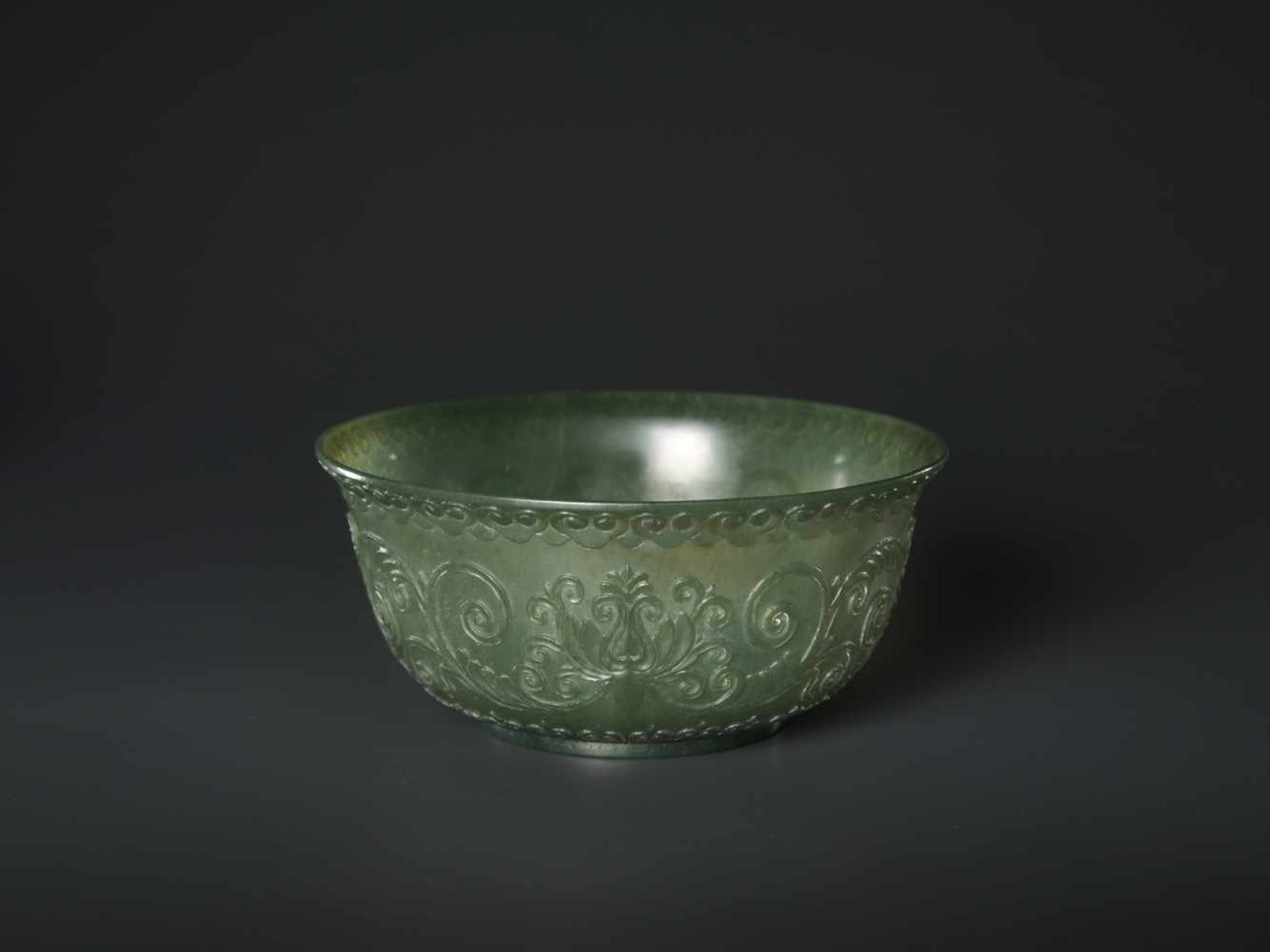 A TRANSLUCENT SPINACH GREEN MUGHAL STYLE ‘LOTUS’ JADE BOWL, QING DYNASTY The jade carved in high - Image 5 of 8