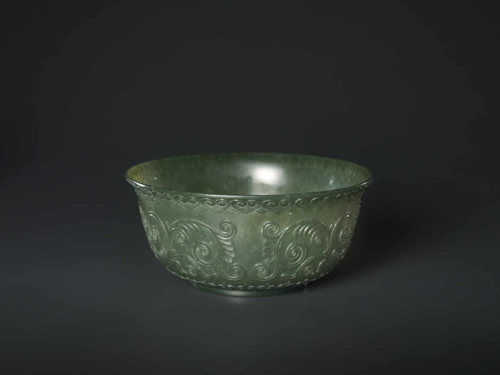 A TRANSLUCENT SPINACH GREEN MUGHAL STYLE ‘LOTUS’ JADE BOWL, QING DYNASTY The jade carved in high - Image 4 of 8