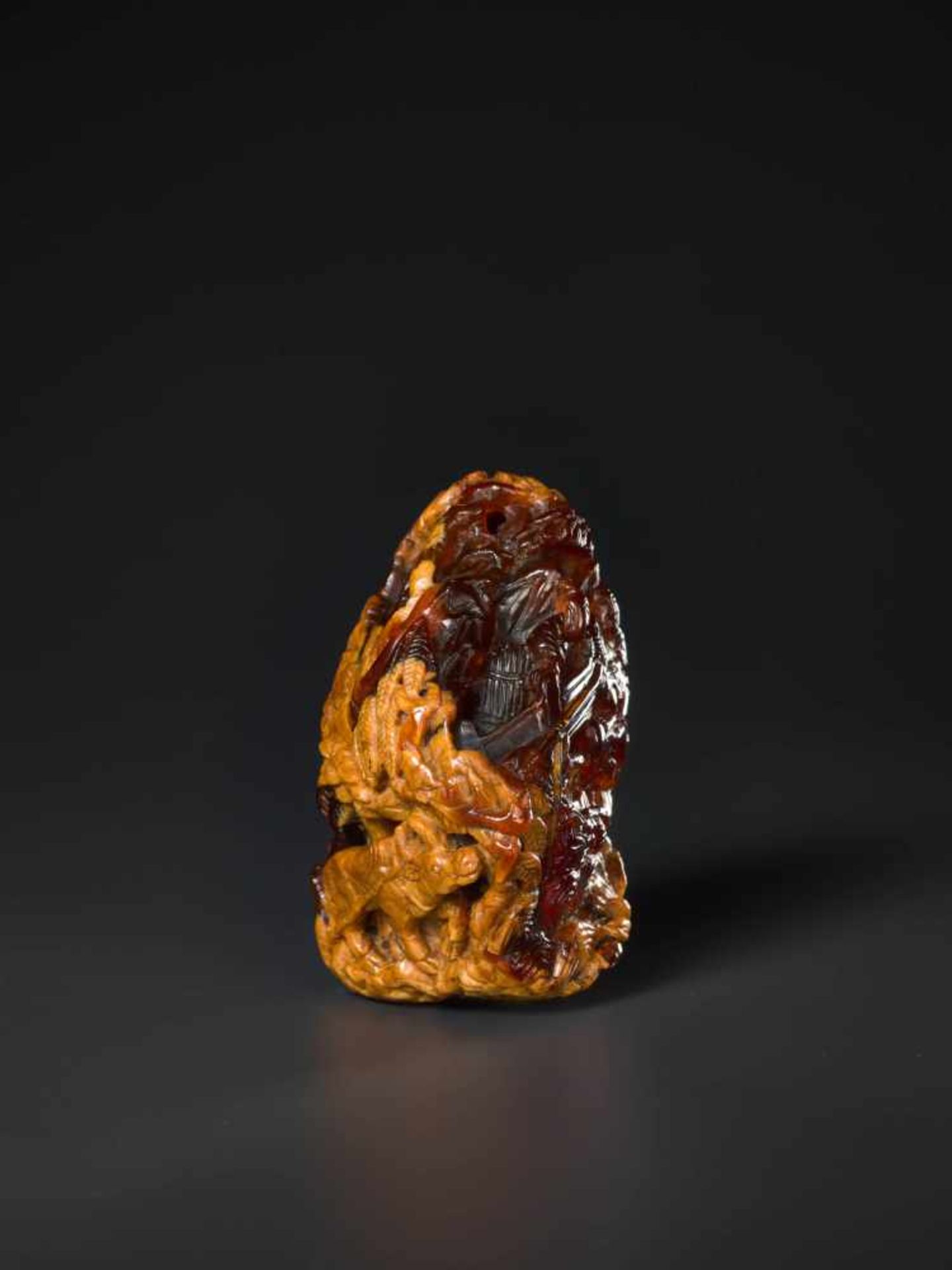 AN 18th CENTURY AMBER PEBBLE CARVING ‘VILLAGE LIFE’ Amber of deep red and caramel color, opaque