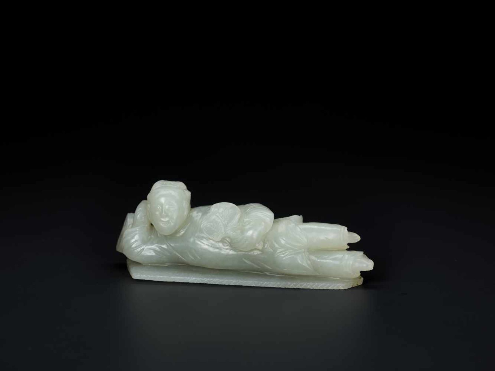 AN 18TH CENTURY CELADON JADE CARVING OF A RECLINING LADY Celadon Jade of an even color with very few