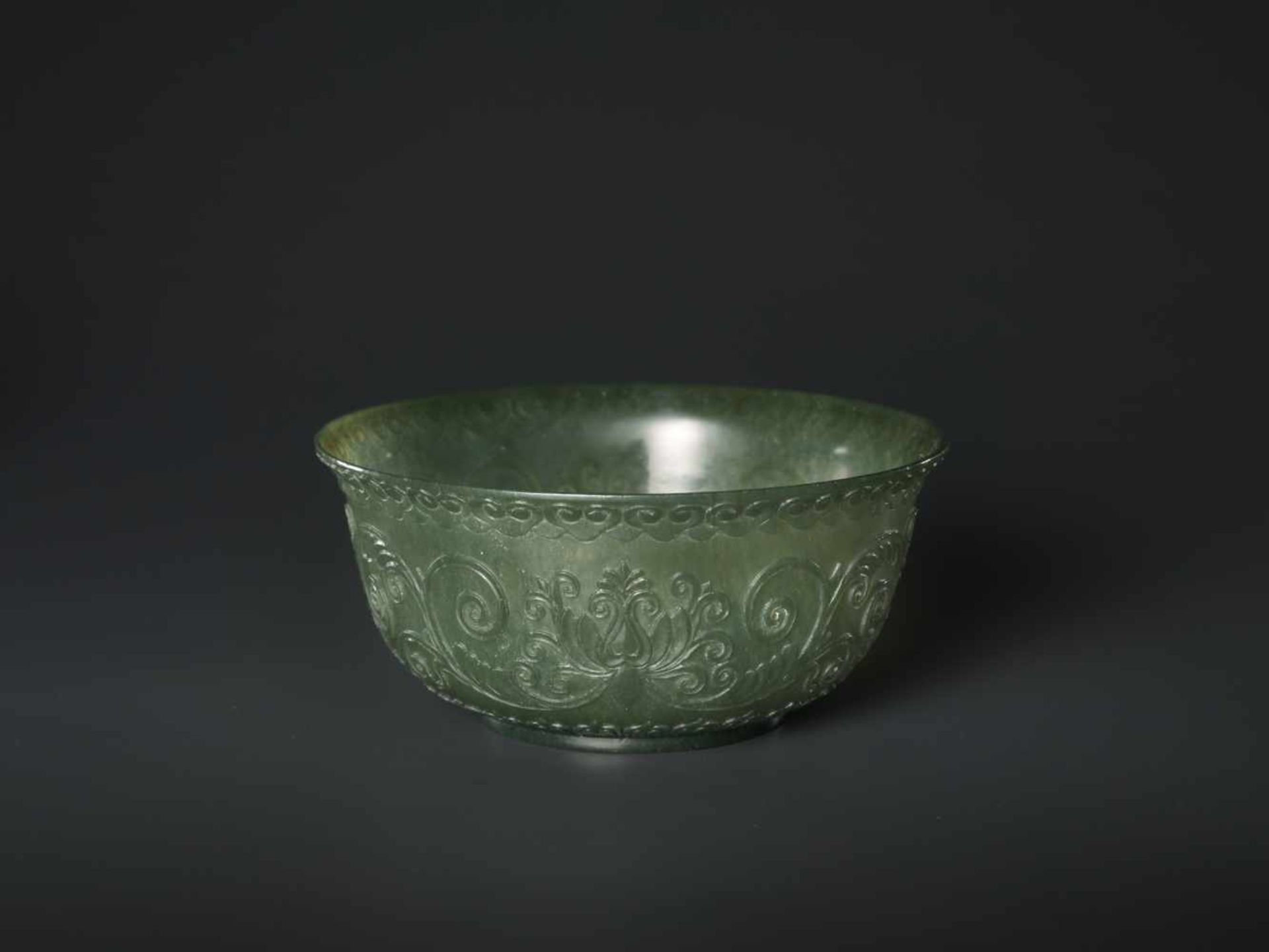 A TRANSLUCENT SPINACH GREEN MUGHAL STYLE ‘LOTUS’ JADE BOWL, QING DYNASTY The jade carved in high - Image 3 of 8