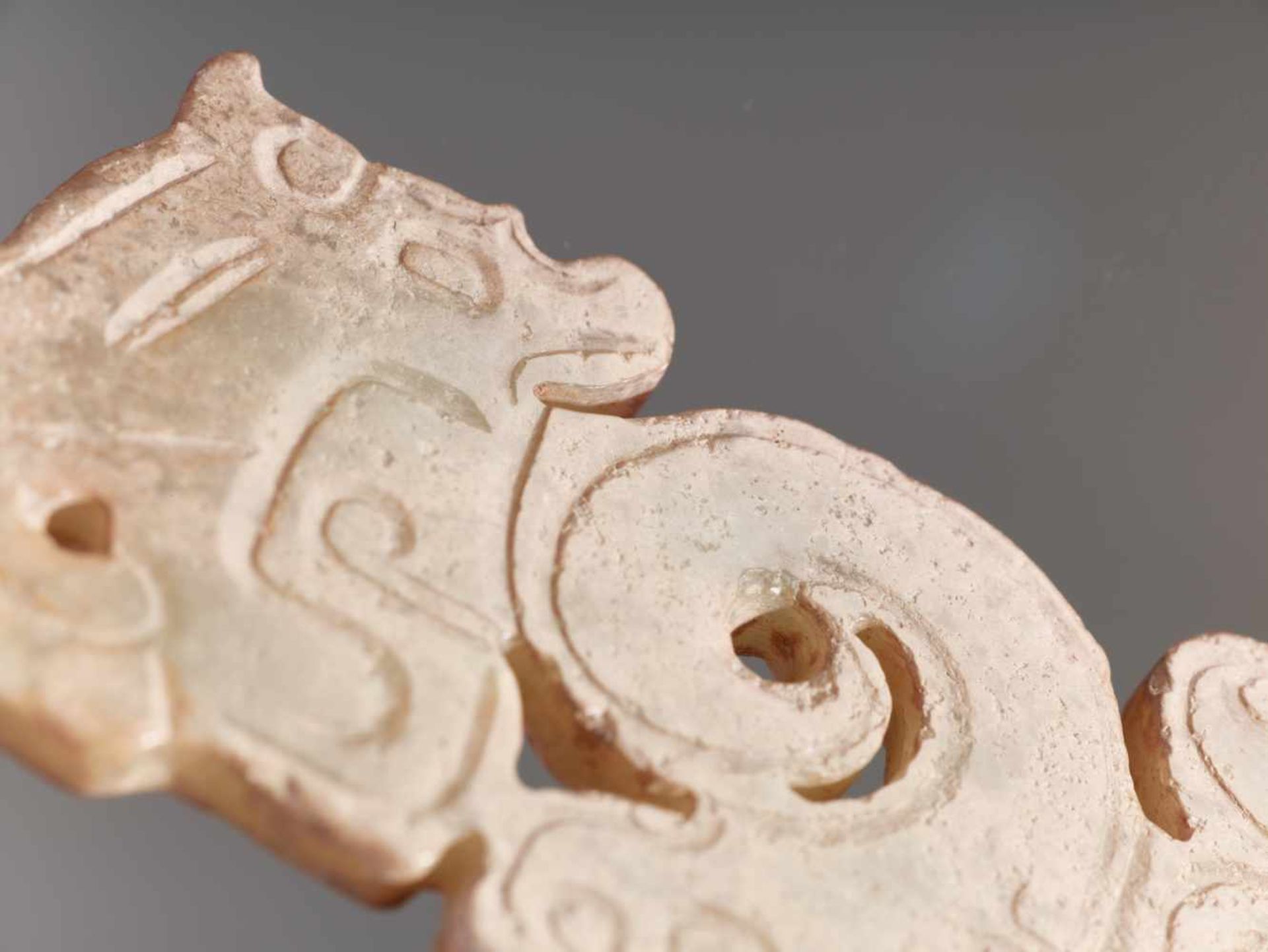 A THIN, FLAT ORNAMENT WITH A COMPOSITE PATTERN OF HUMAN HEADS AND DRAGONS Jade. China, Western Zhou, - Image 8 of 11