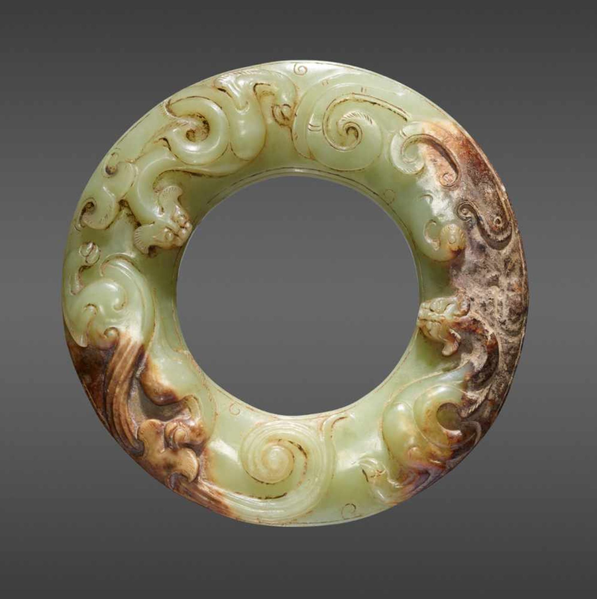 A STUNNING CELADON GREEN DISC EXQUISITELY CARVED WITH TWO CHI DRAGONS IN RELIEF ON TOP AND JOINED
