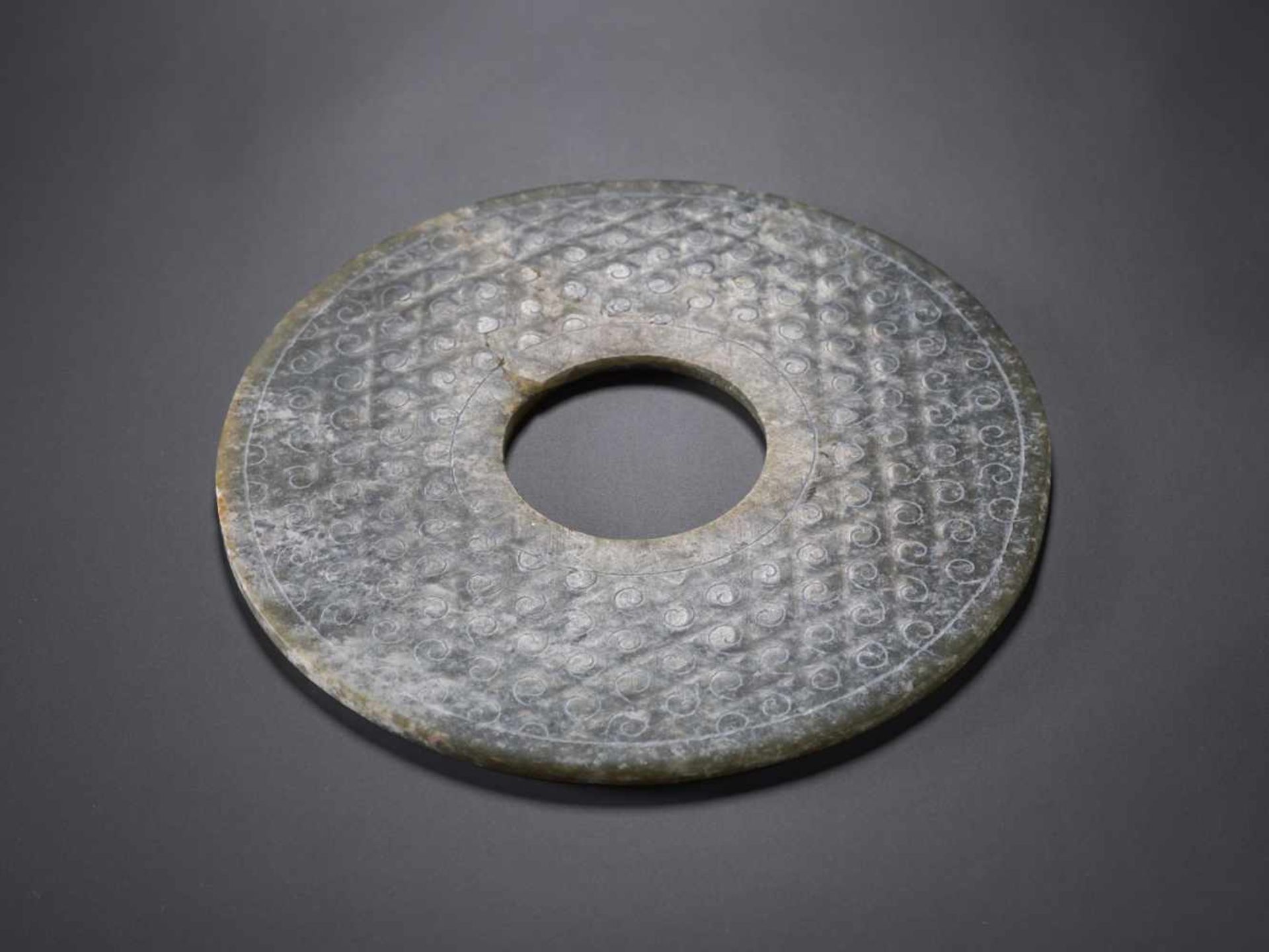 A REFINED CHARCOAL GREY DISC WITH ENGRAVED CURLS Jade. China, Han Dynasty, 2nd century BC 穀紋玉璧 - 漢代, - Image 3 of 8