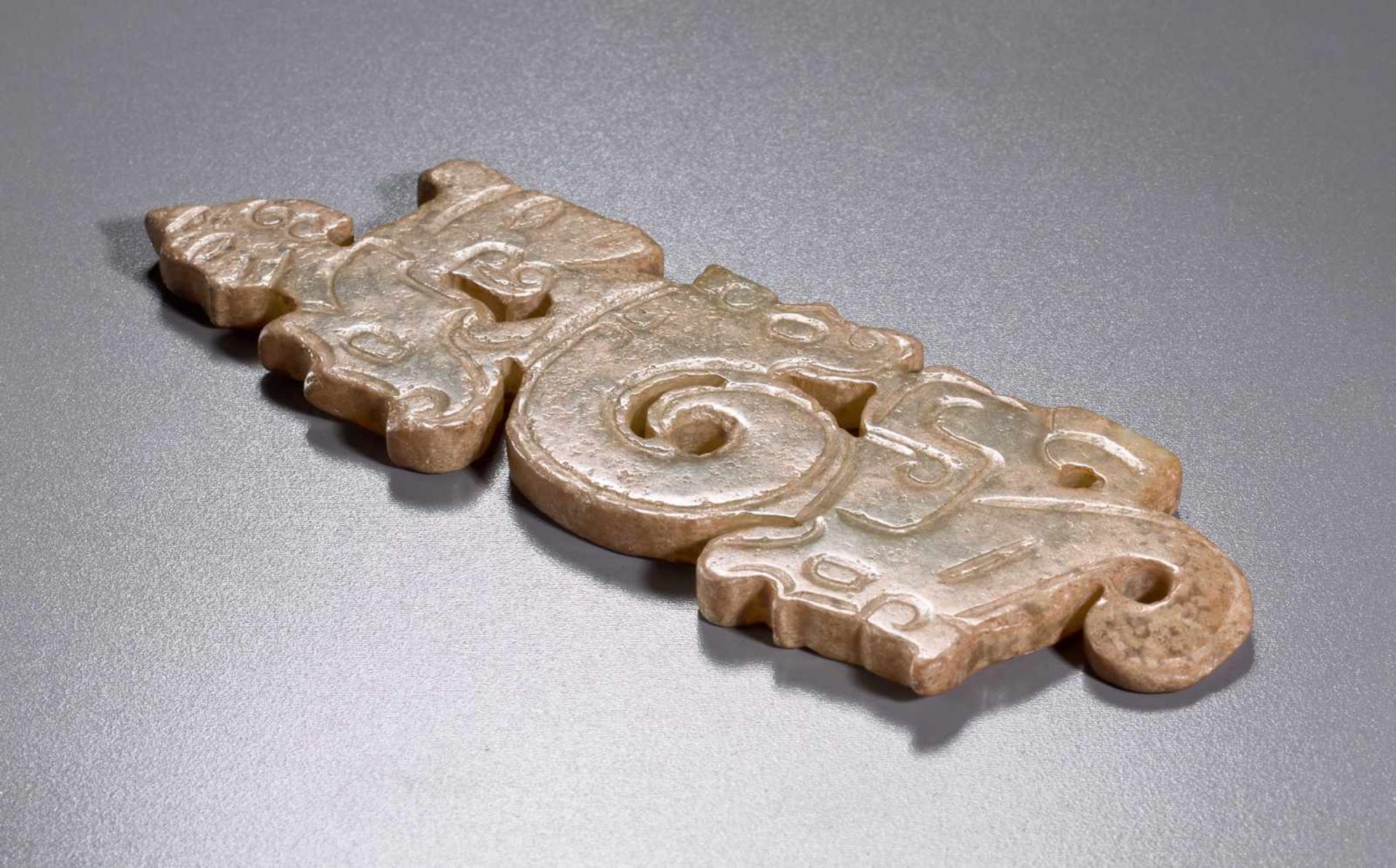 A THIN, FLAT ORNAMENT WITH A COMPOSITE PATTERN OF HUMAN HEADS AND DRAGONS Jade. China, Western Zhou, - Image 5 of 11