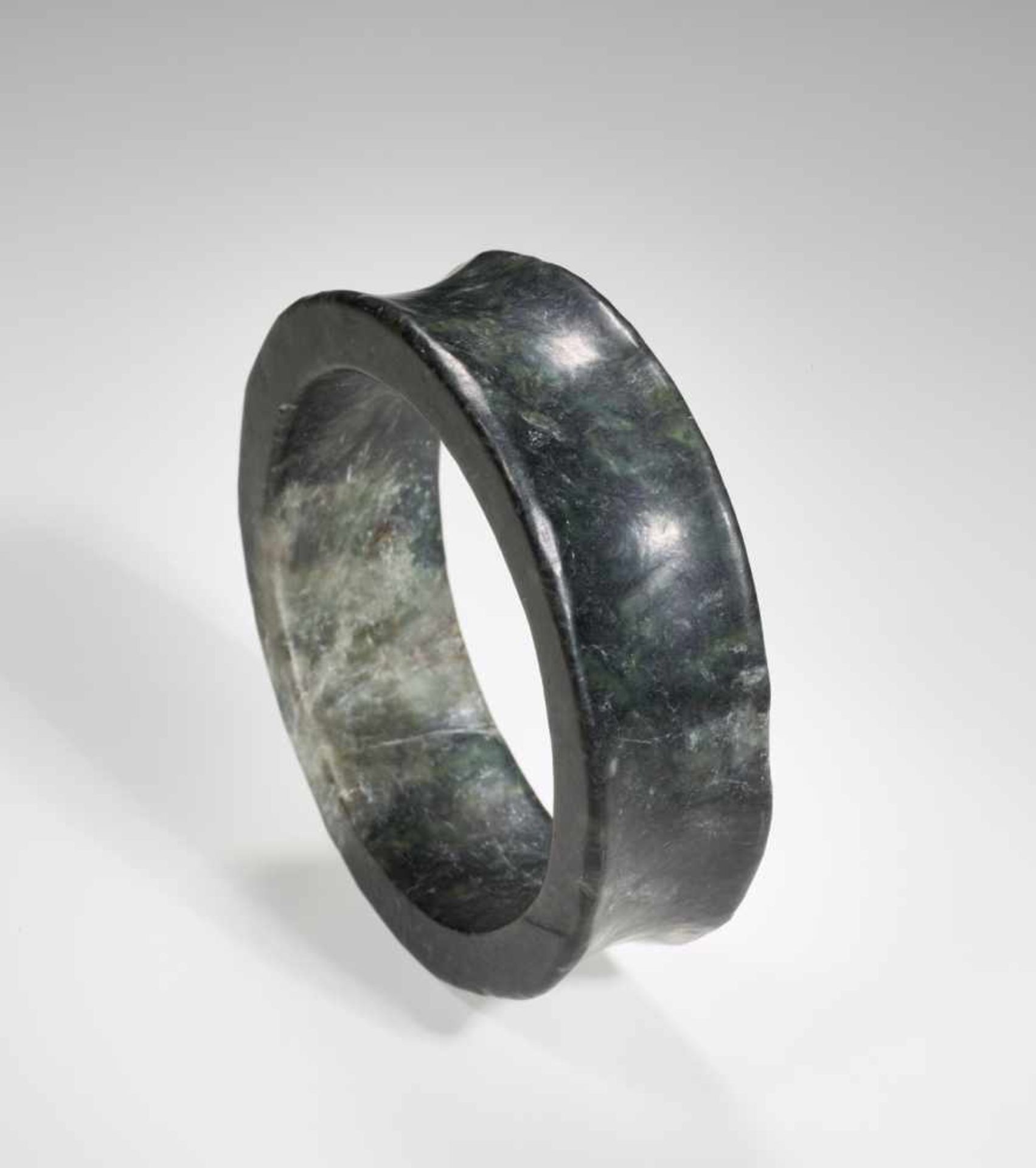AN ELEGANT NEOLITHIC BRACELET IN DARK GREEN JADE WITH A SMOOTH CONCAVE BORDER Jade. China, Late