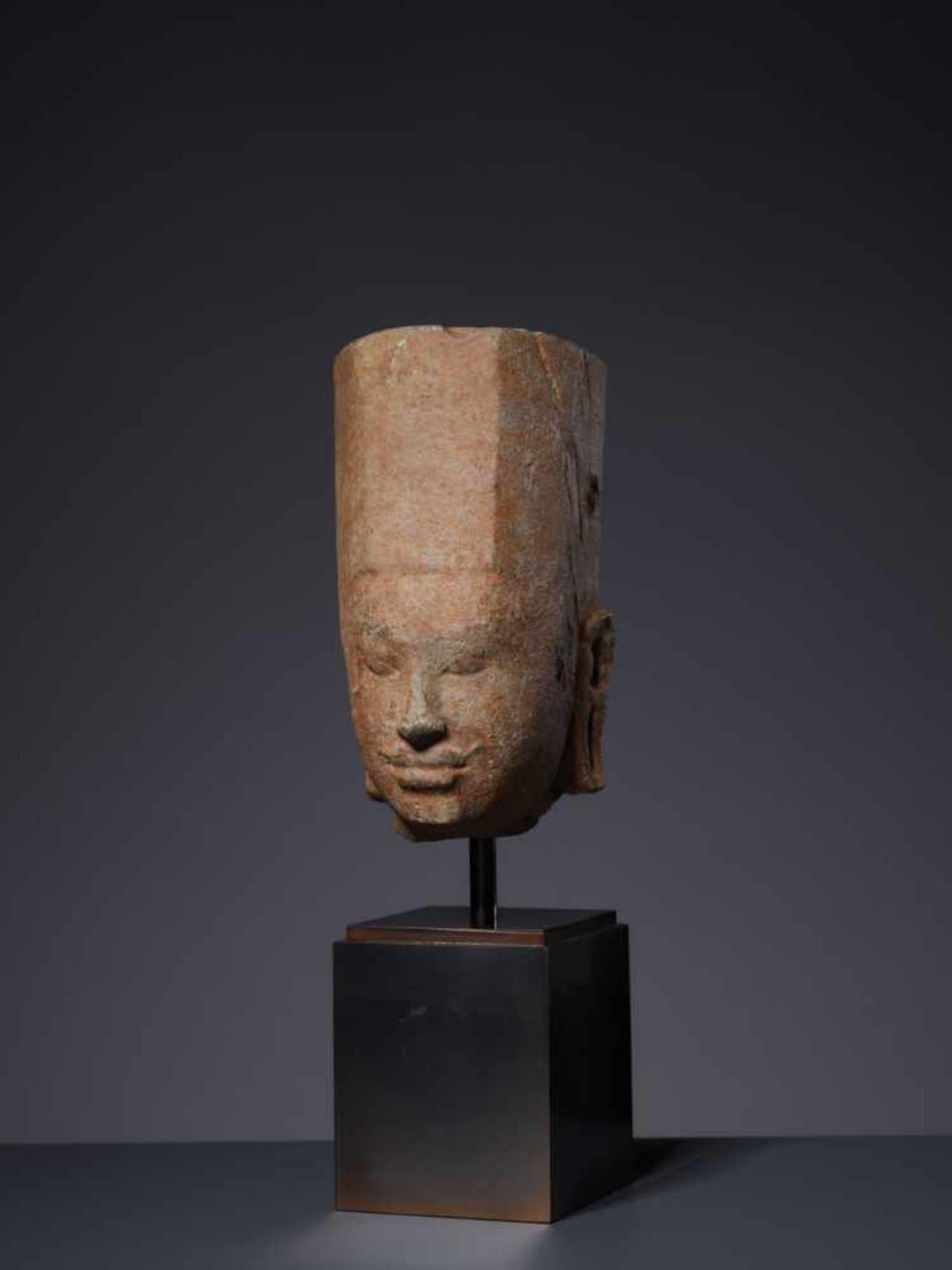 A SANDSTONE HEAD OF A DEITY, KHMER, PRE-ANGKOR PERIOD, 7TH – 8TH CENTURY Sculptured and chiseled