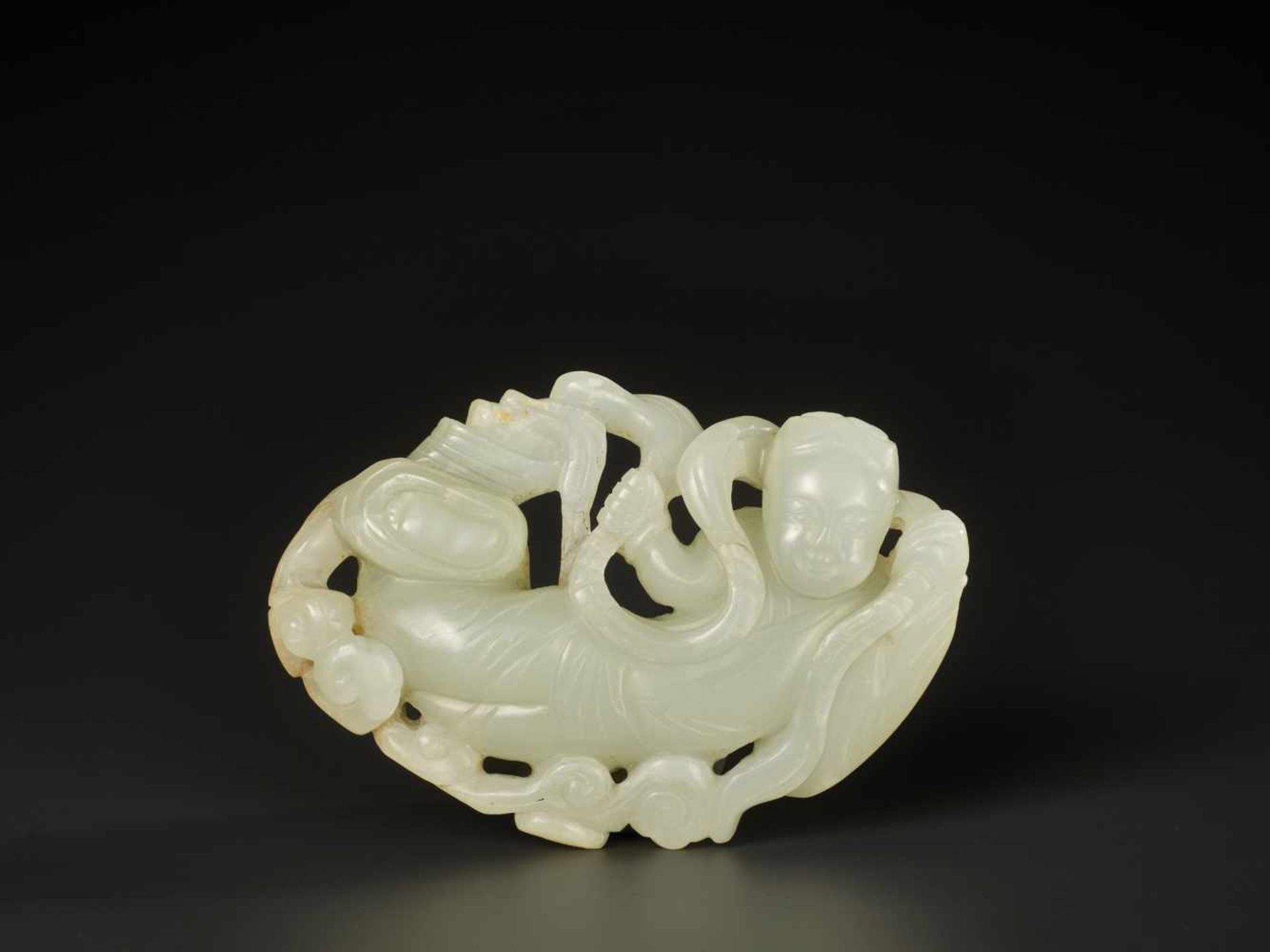 A WHITE JADE CARVING OF AN APSARA, MING DYNASTY OR EARLIER The stone is of an even tone, with a