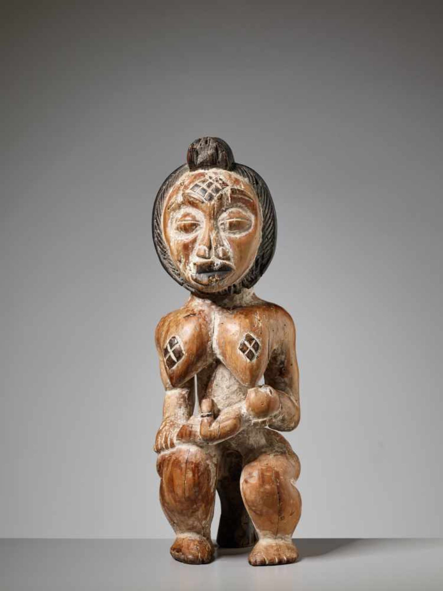 A WOOD MATERNITY FIGURE, GABON, PUNU PEOPLEPainted wood, kaolinGabon, Punu people20th centuryThe