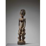 A BOMBOU TORO SCULPTURE OF A SEATED NOMMO, MALI, DOGON PEOPLEWood with remnants of paintMali,